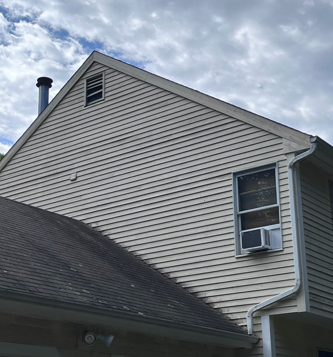 A white house with a chimney on top of it