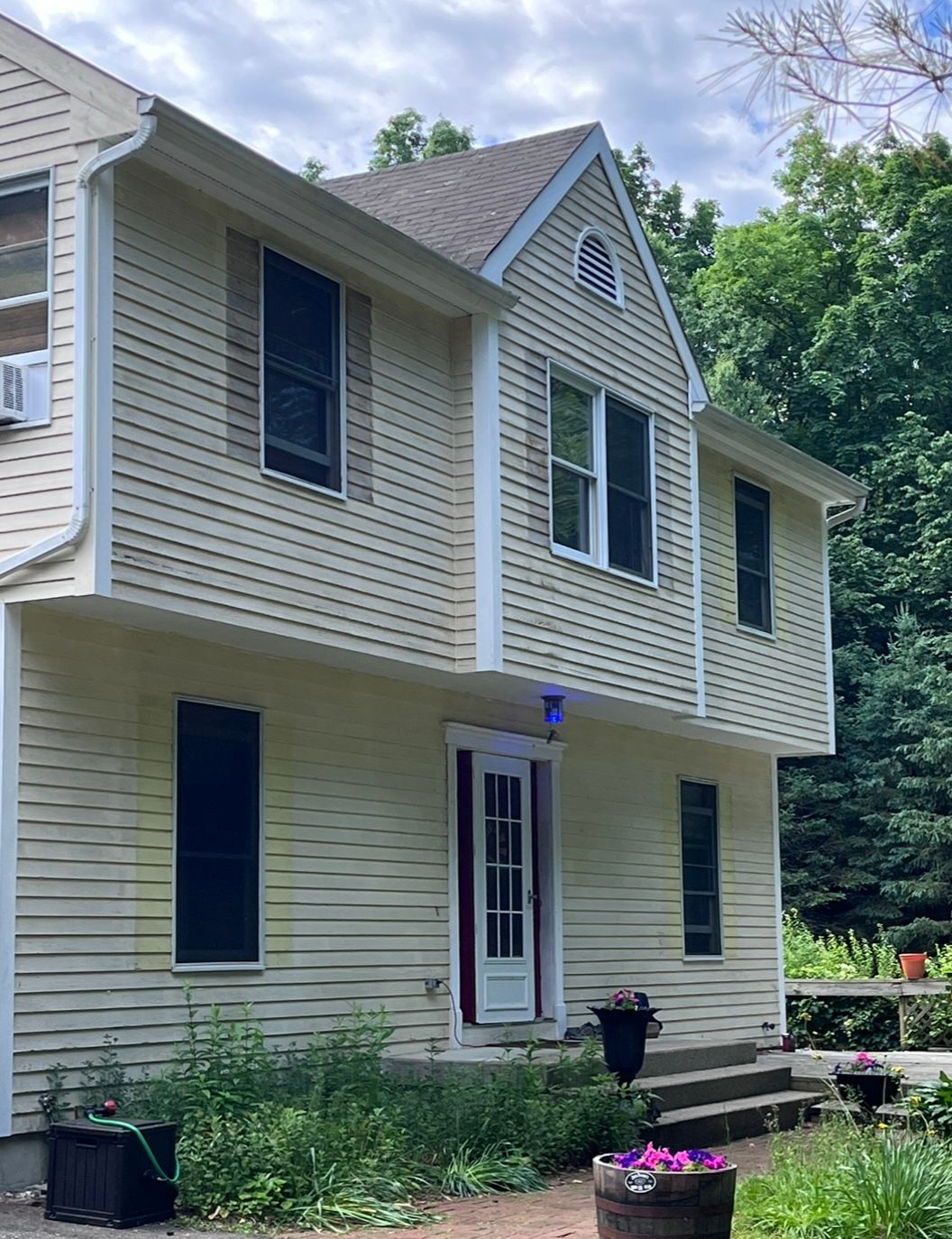 A large house with a lot of windows is surrounded by trees.