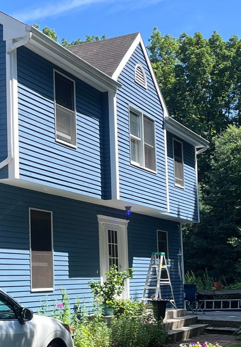 A blue house with a white car parked in front of it
