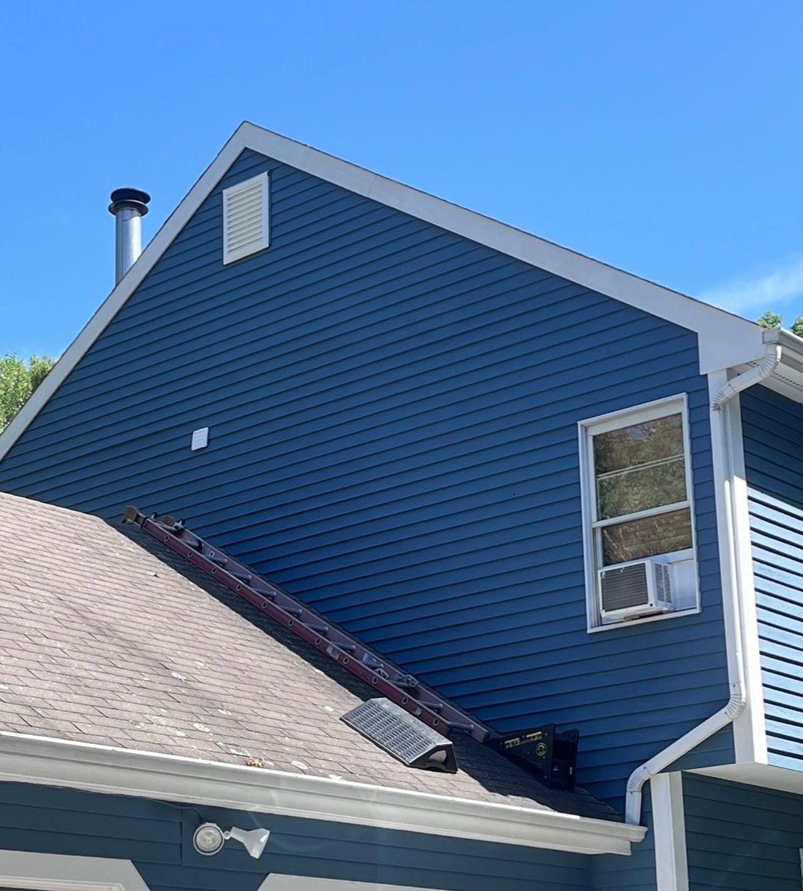 A blue house with a chimney on the roof
