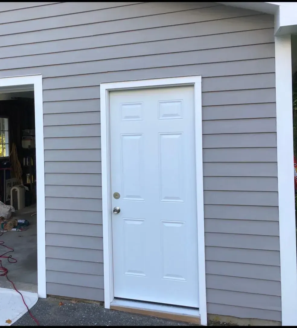 A white door is on the side of a building.