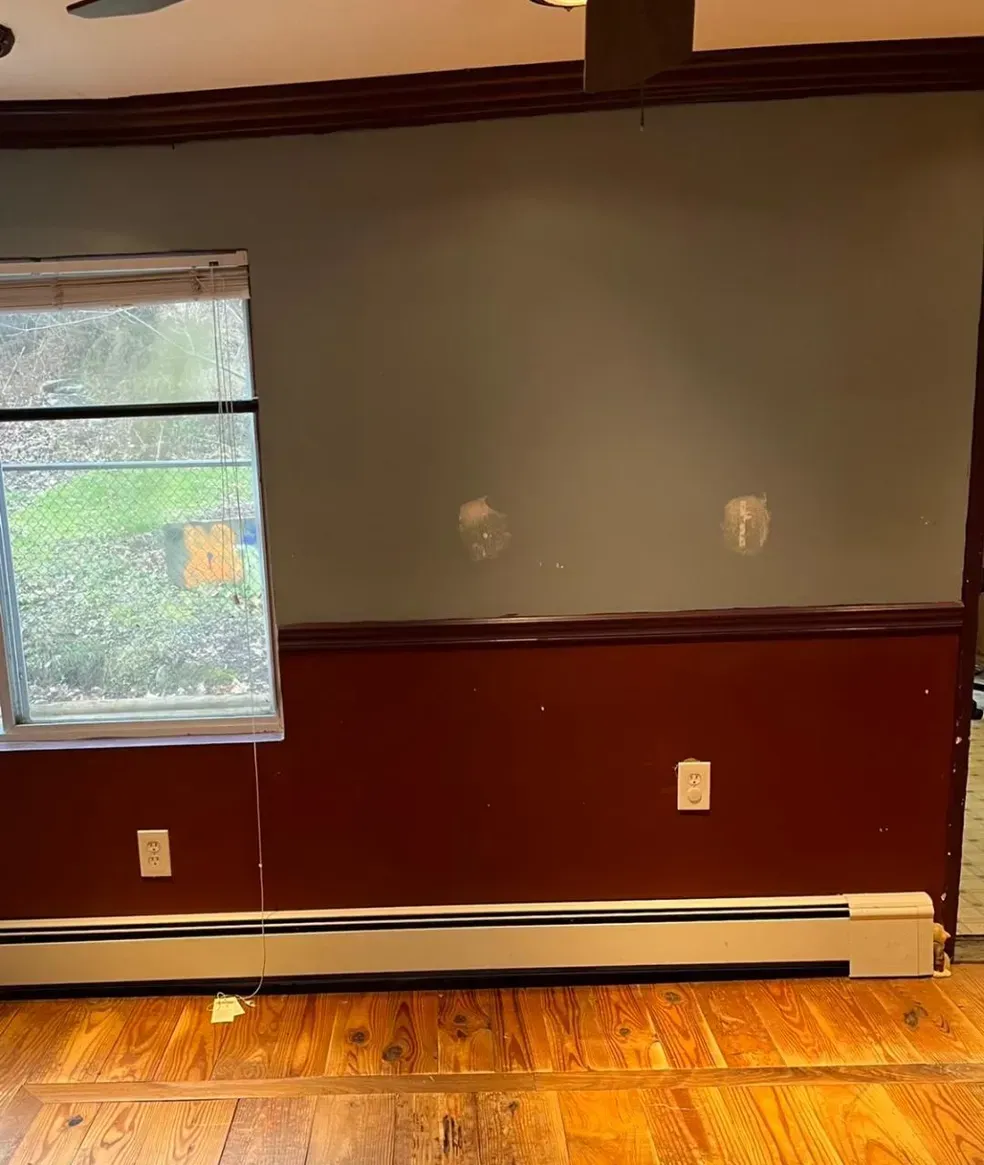 A living room with hardwood floors and a window.