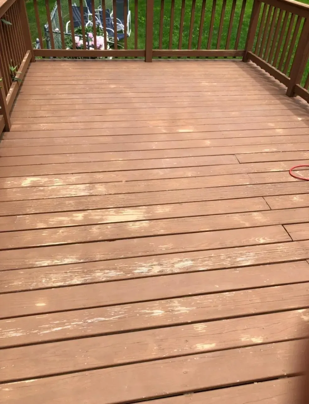A wooden deck with a fence and a person standing on it.