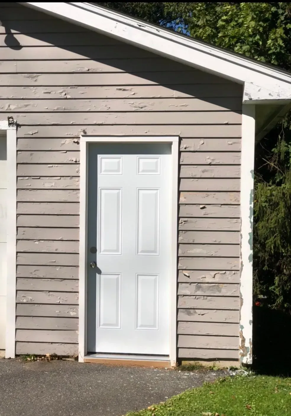 A white door is on the side of a building