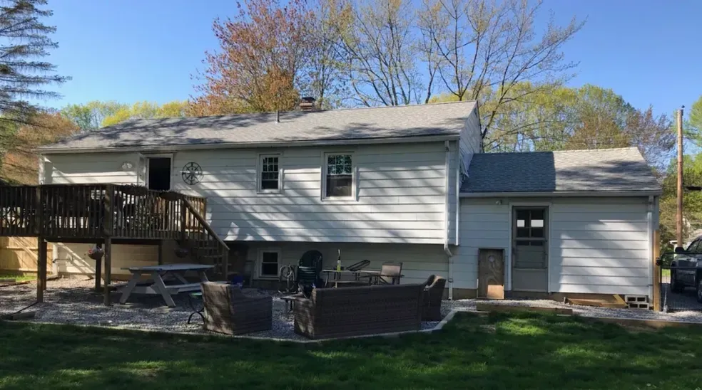 The back of a house with a large deck and patio area.