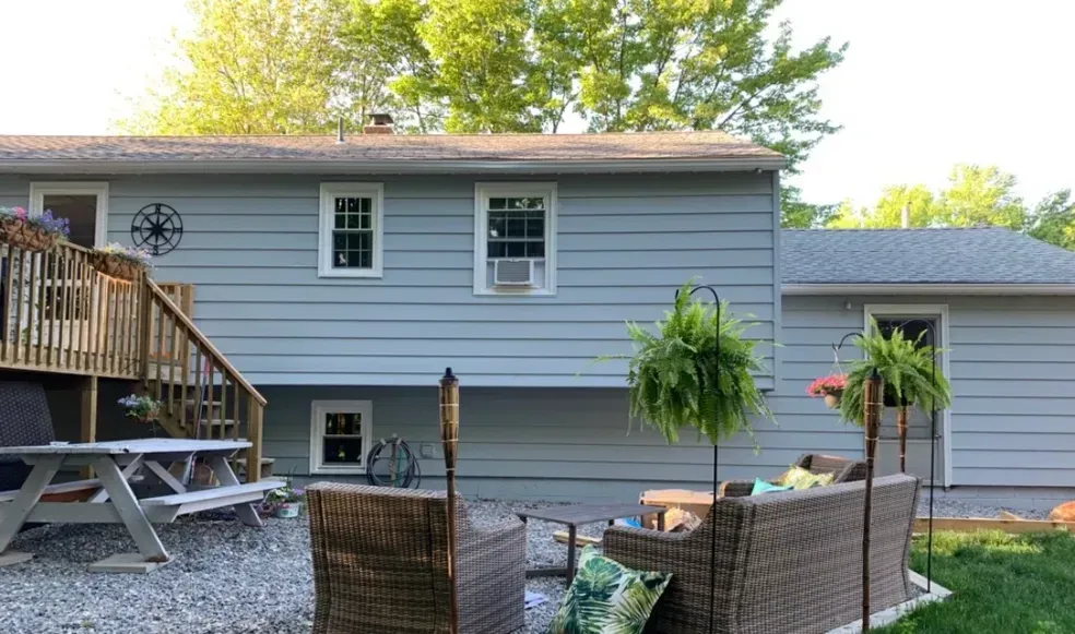 A house with a patio and a picnic table in front of it.