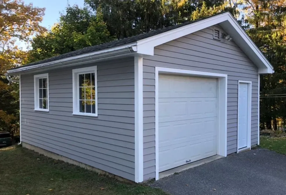 A gray garage with a white garage door and windows