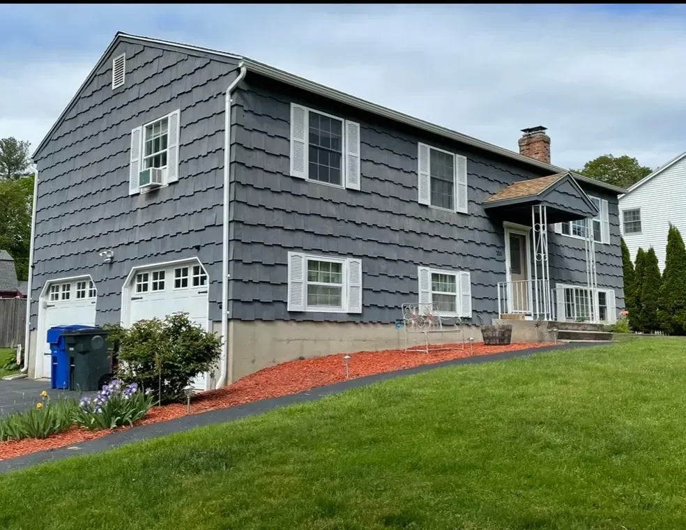 A large house with a gray siding and white shutters