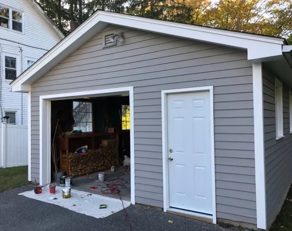 A garage is being painted in a gray and white color.
