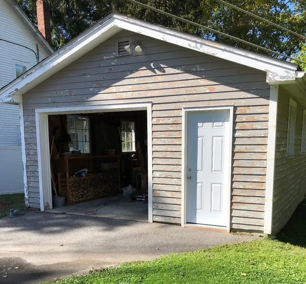 A garage with a white door and a wooden siding