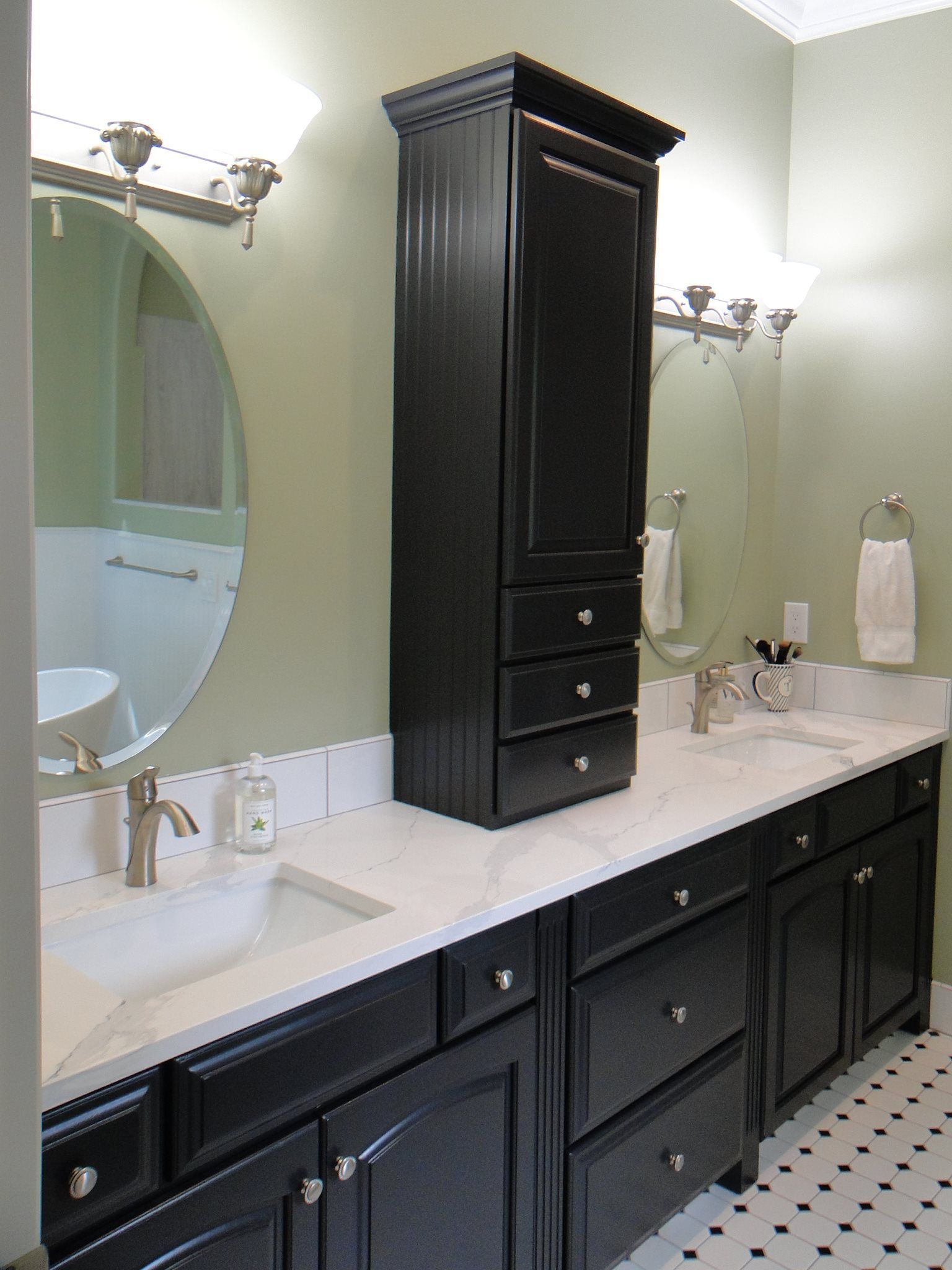 A bathroom with two sinks and a large mirror