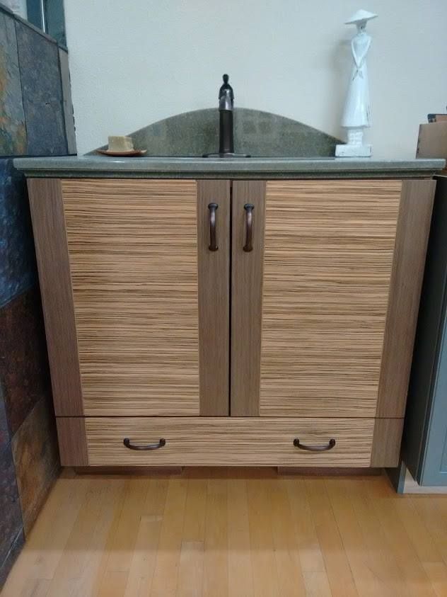 A bathroom sink with a wooden cabinet underneath it