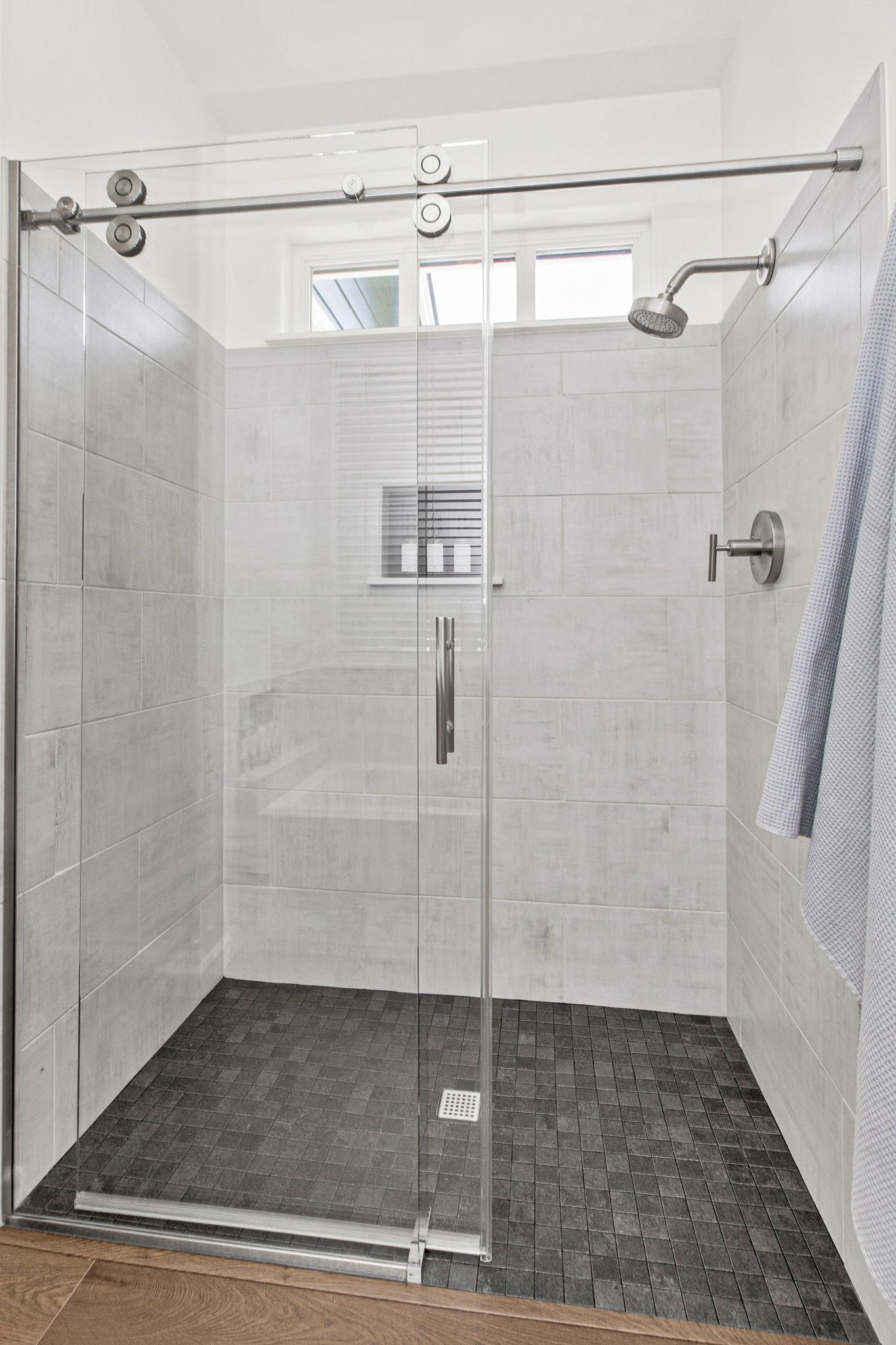 A bathroom with a walk in shower with a sliding glass door.