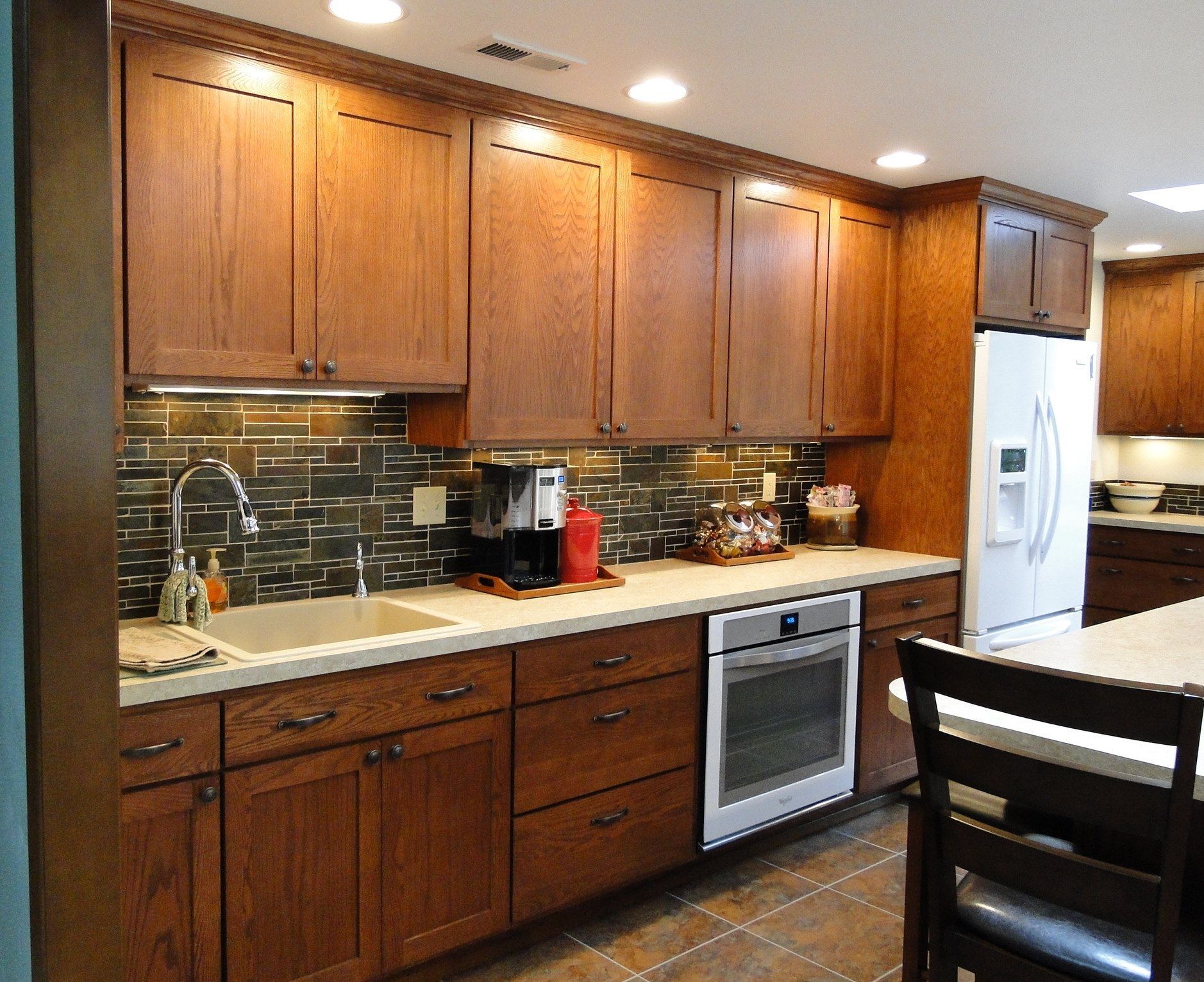 A kitchen with wooden cabinets and a white refrigerator