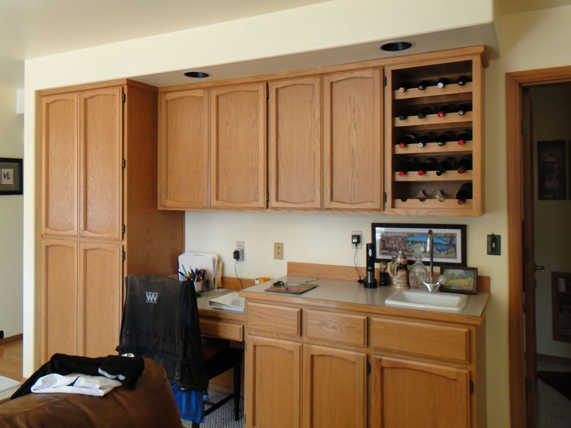 A kitchen with wooden cabinets and a wine rack