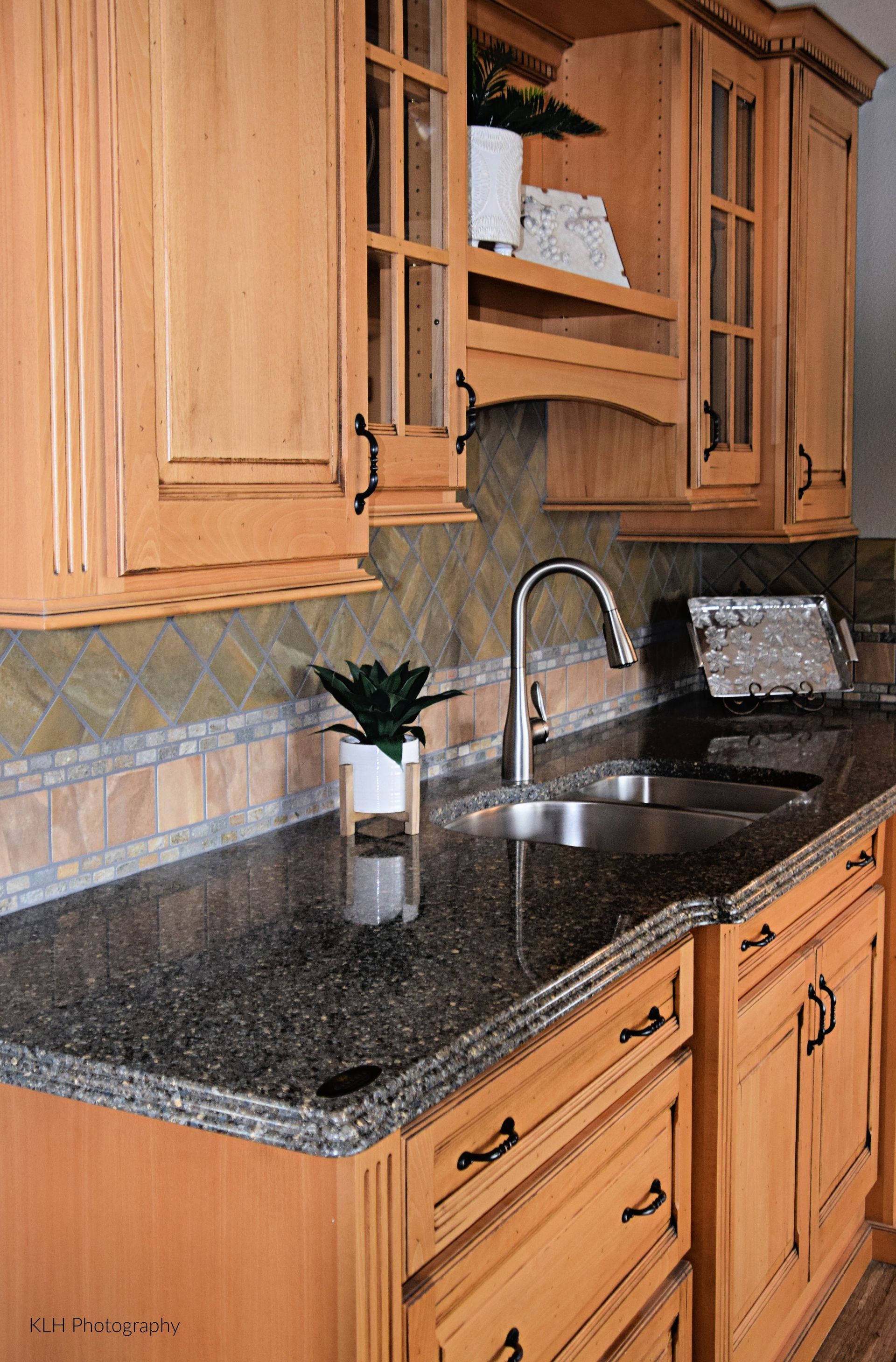 A kitchen with granite counter tops and wooden cabinets