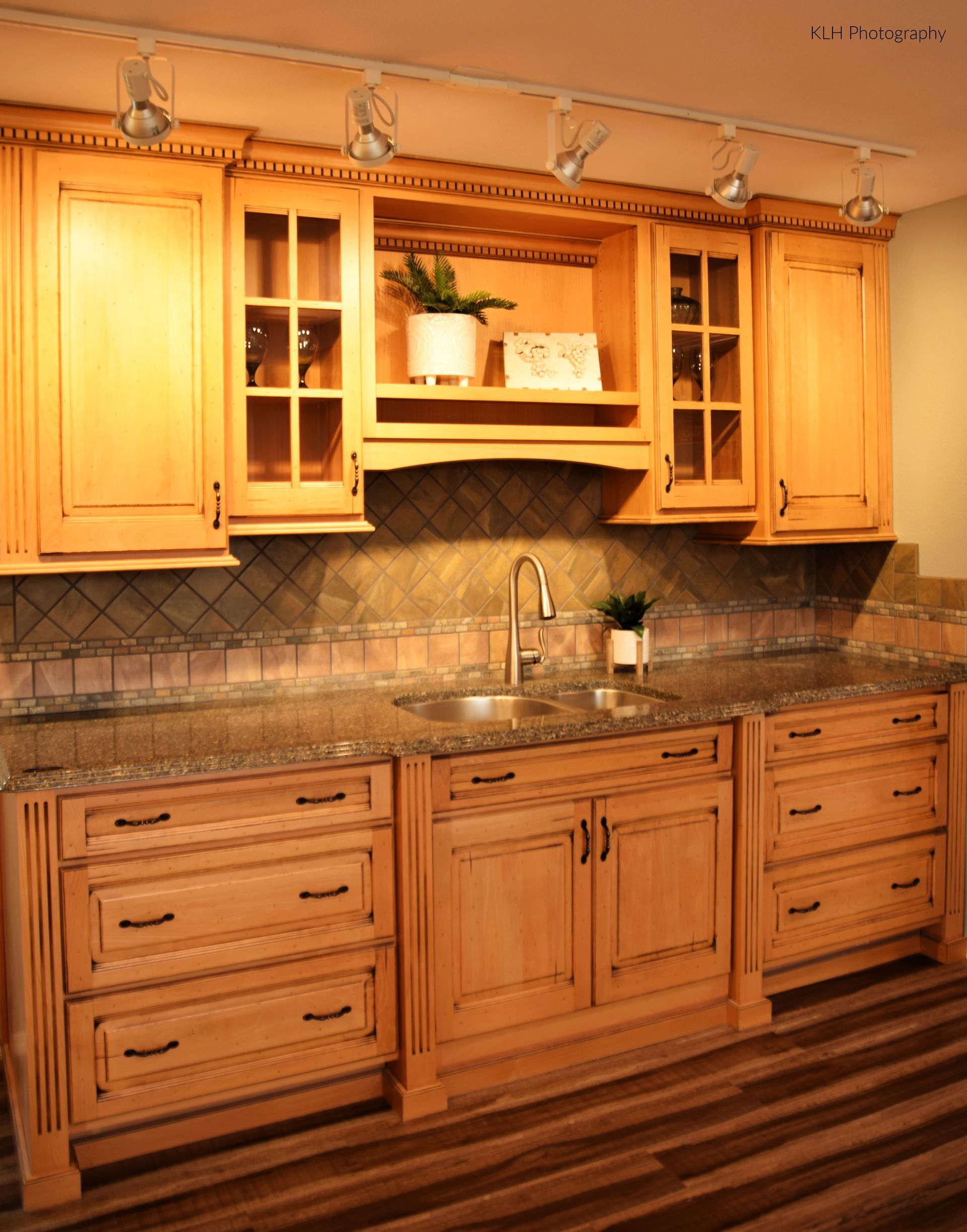 A kitchen with wooden cabinets and granite counter tops