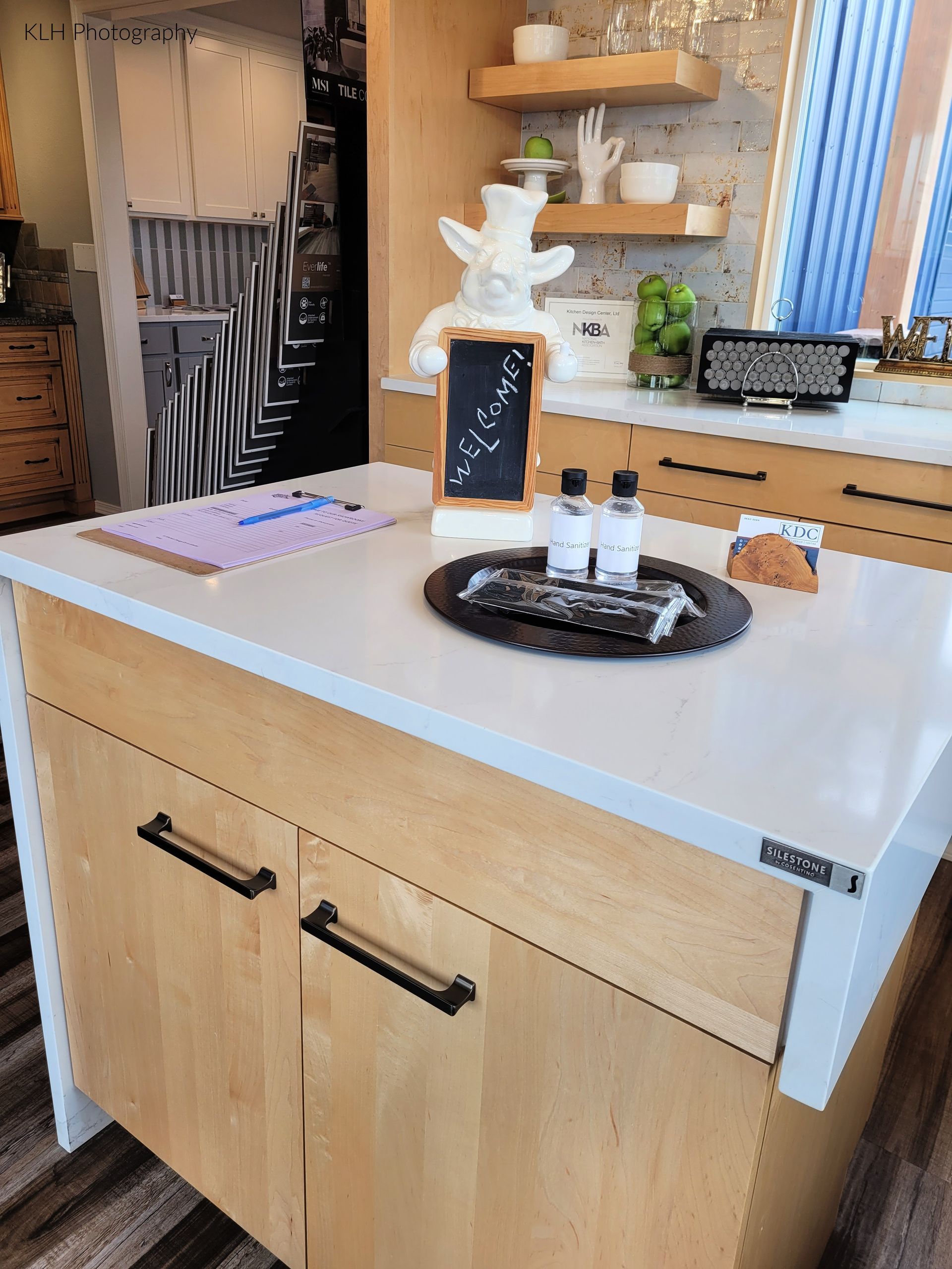 A kitchen with a wooden island and a white counter top.