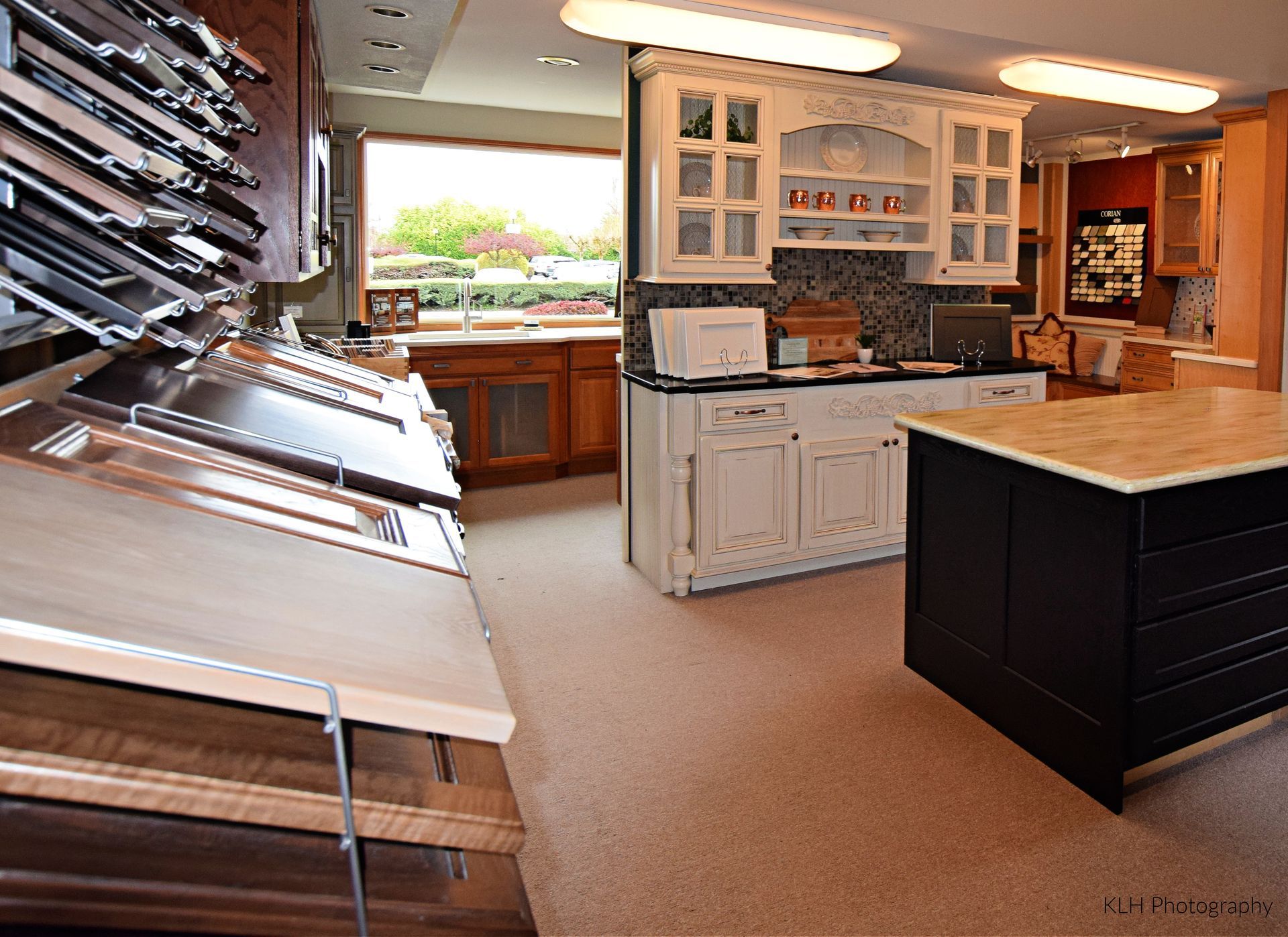 A kitchen with white cabinets and a black island