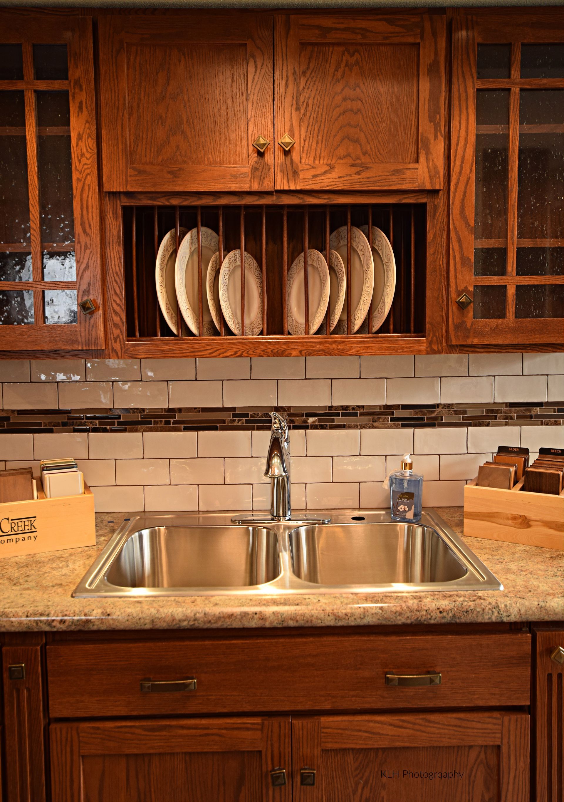 A kitchen with a sink and a plate rack above it