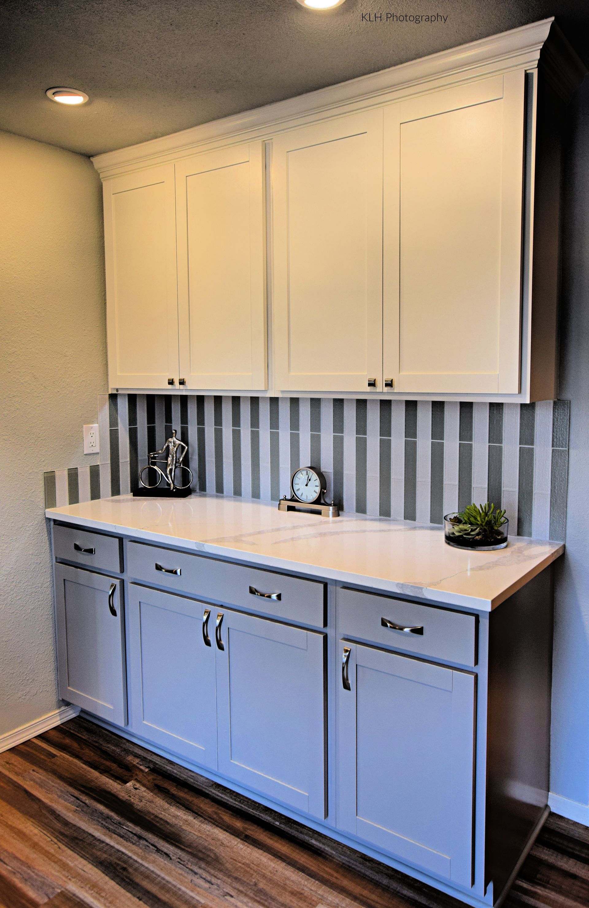 A kitchen with white cabinets and a clock on the counter.