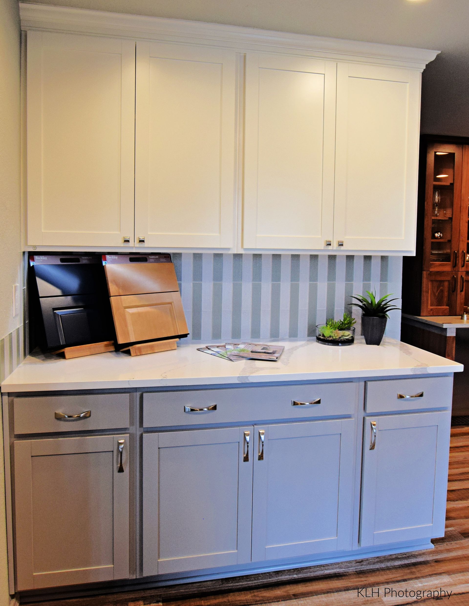 A kitchen with white cabinets and gray drawers