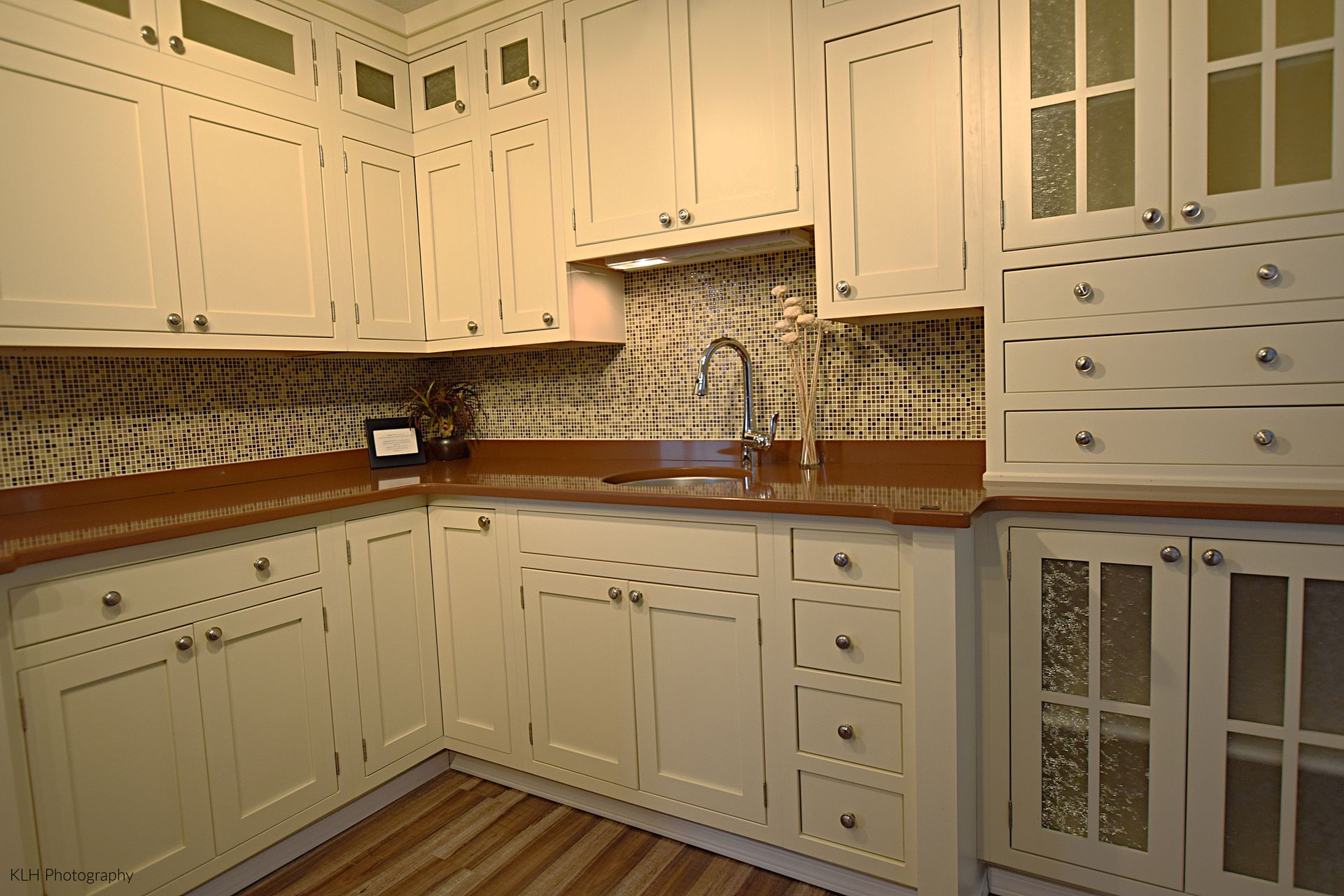 A kitchen with white cabinets and a sink