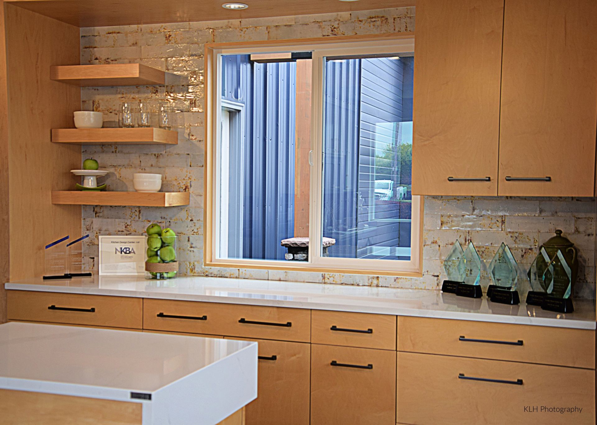 A kitchen with wooden cabinets and a large window