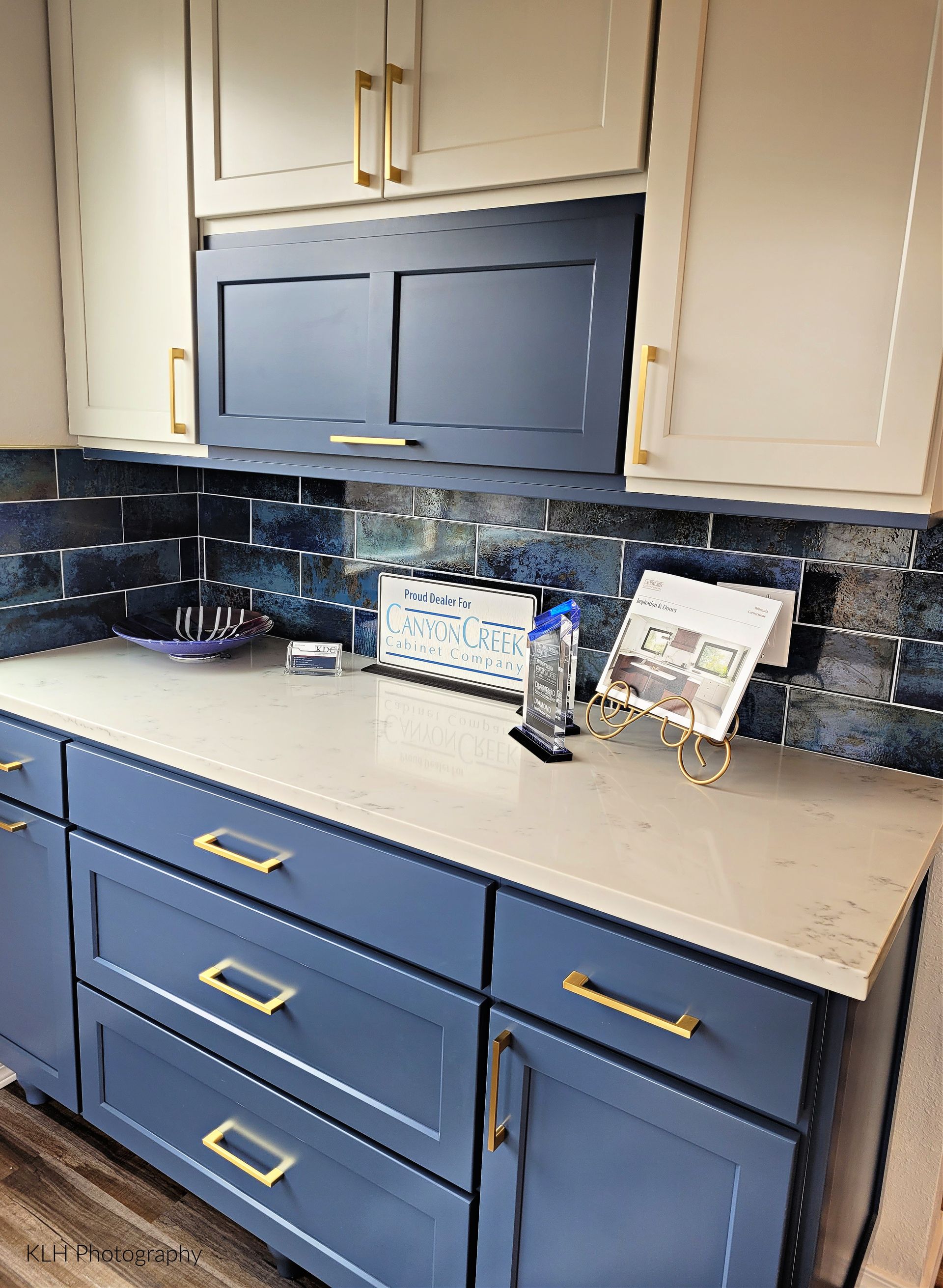 A kitchen with blue cabinets and white counter tops.
