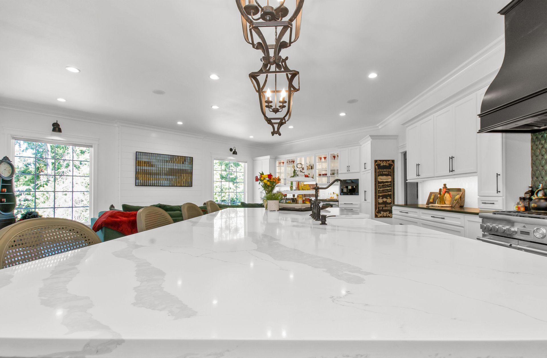 A kitchen with a large island and white counter tops.