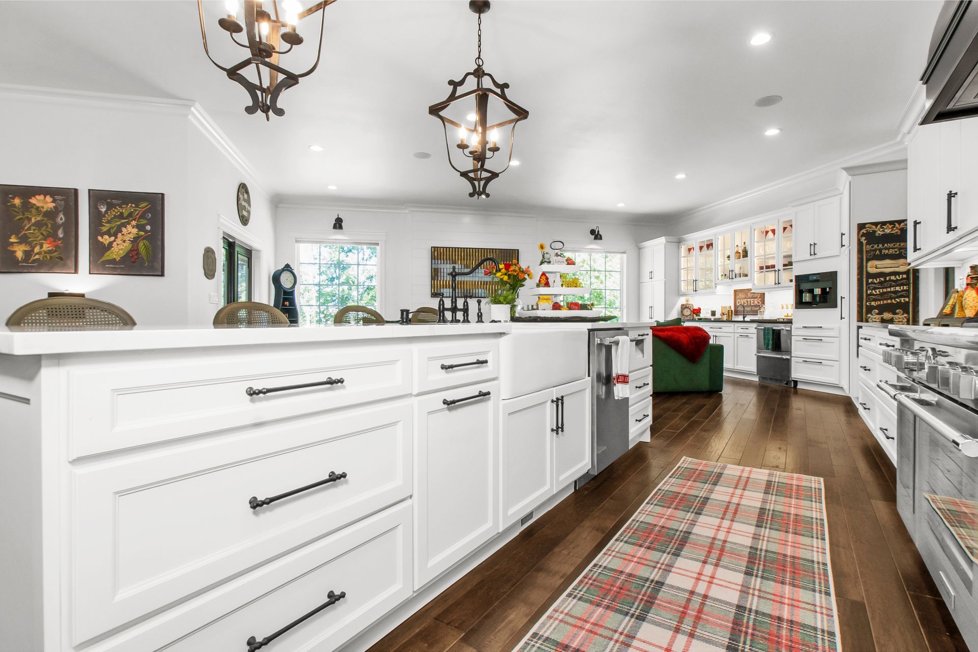 A kitchen with white cabinets and stainless steel appliances and a rug on the floor.