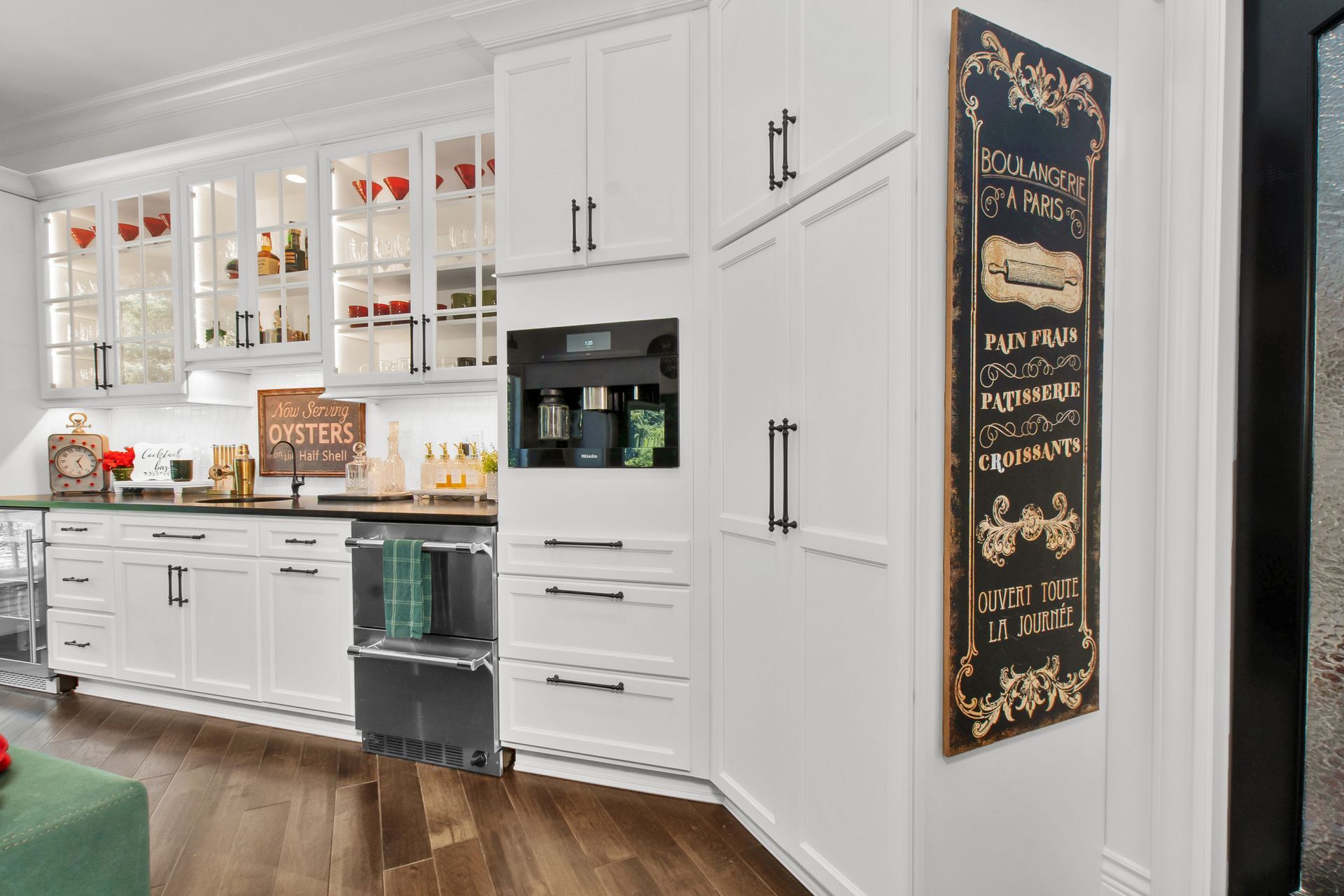 A kitchen with white cabinets and a chalkboard on the wall.
