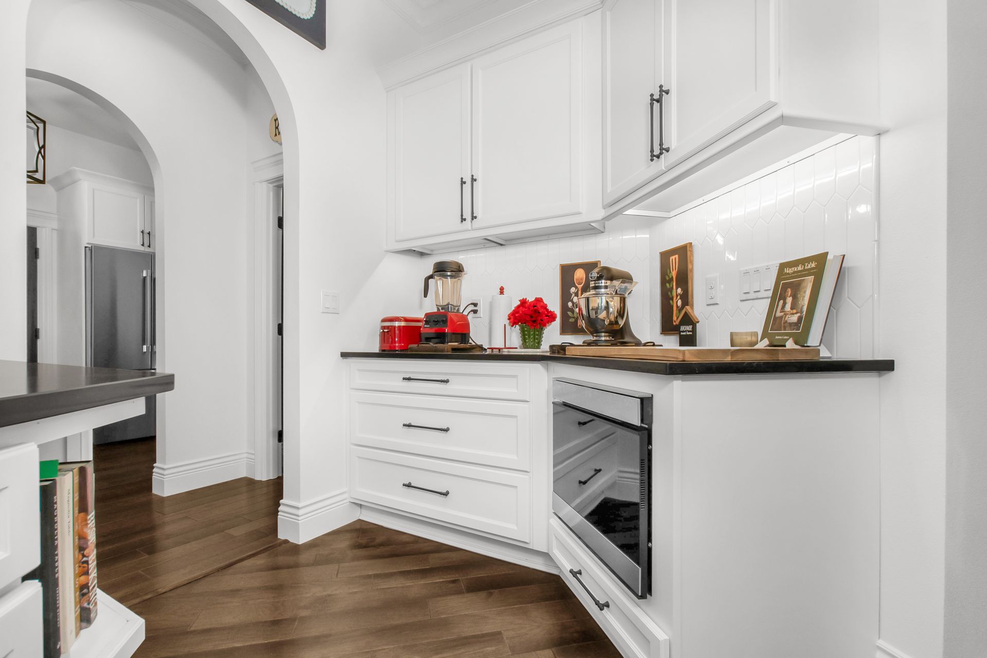 A kitchen with white cabinets and a stainless steel oven.