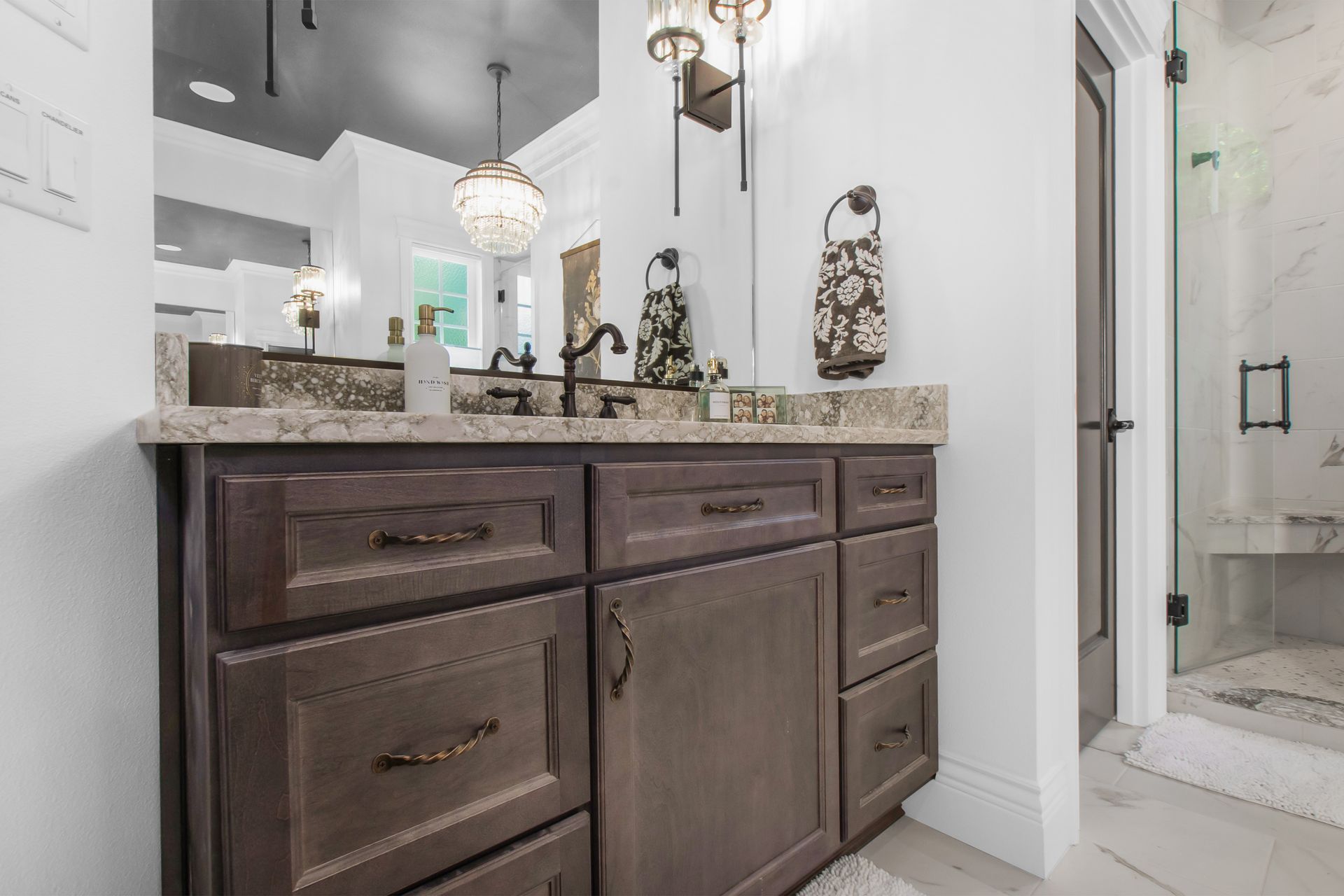 A bathroom with two sinks , a mirror , and a walk in shower.