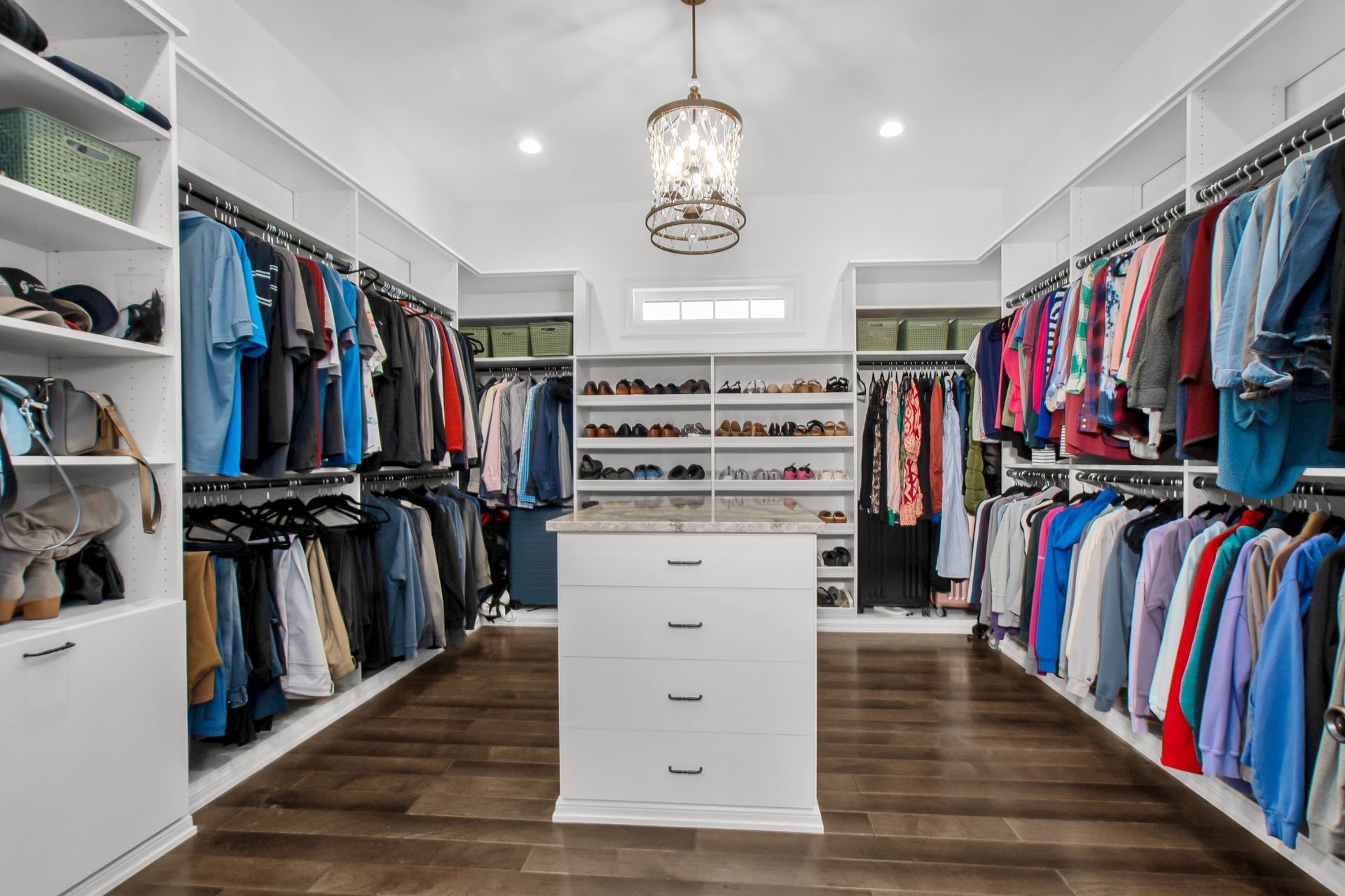 A large walk in closet filled with lots of clothes and shoes.