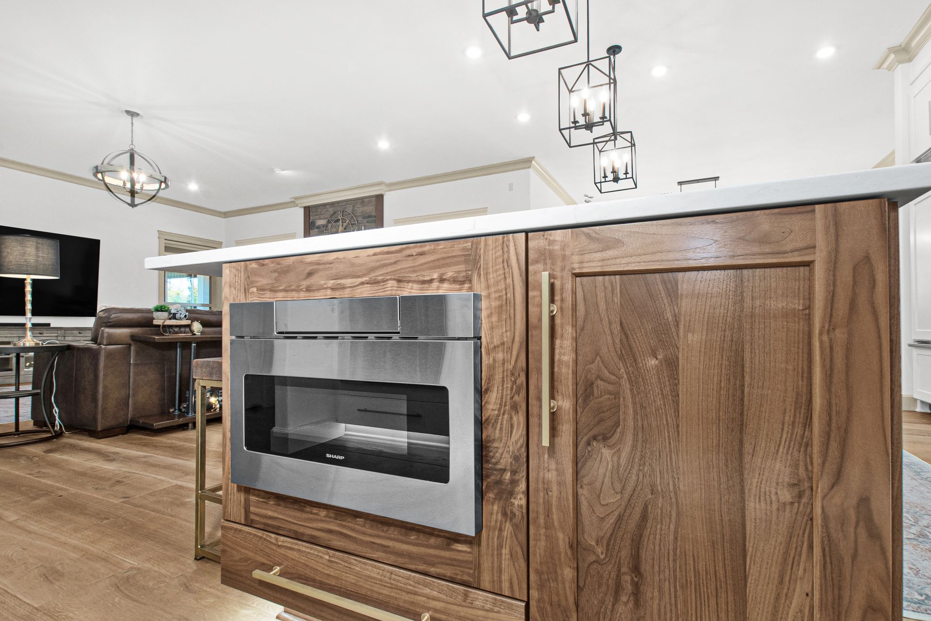 A kitchen with wooden cabinets and a stainless steel microwave oven.