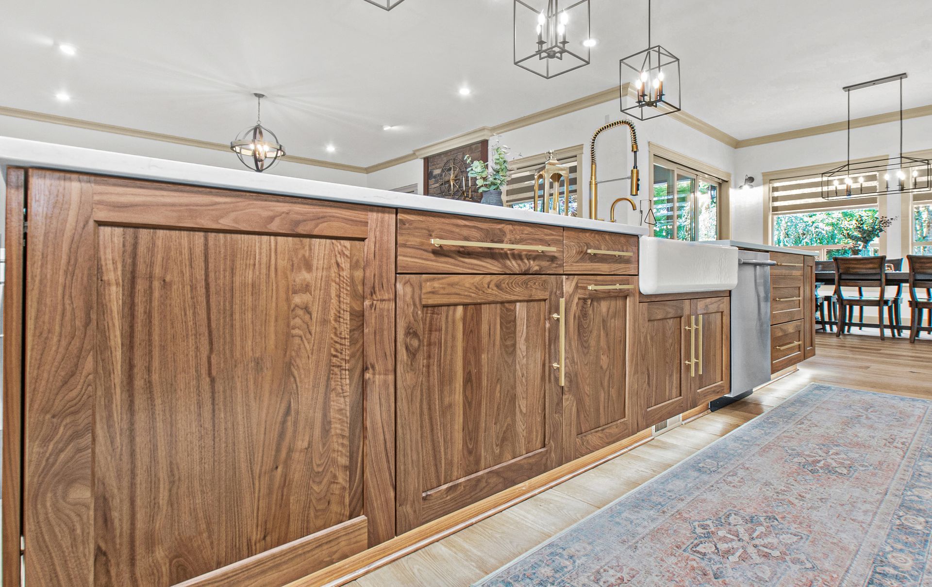A kitchen with wooden cabinets , a sink , and a rug.