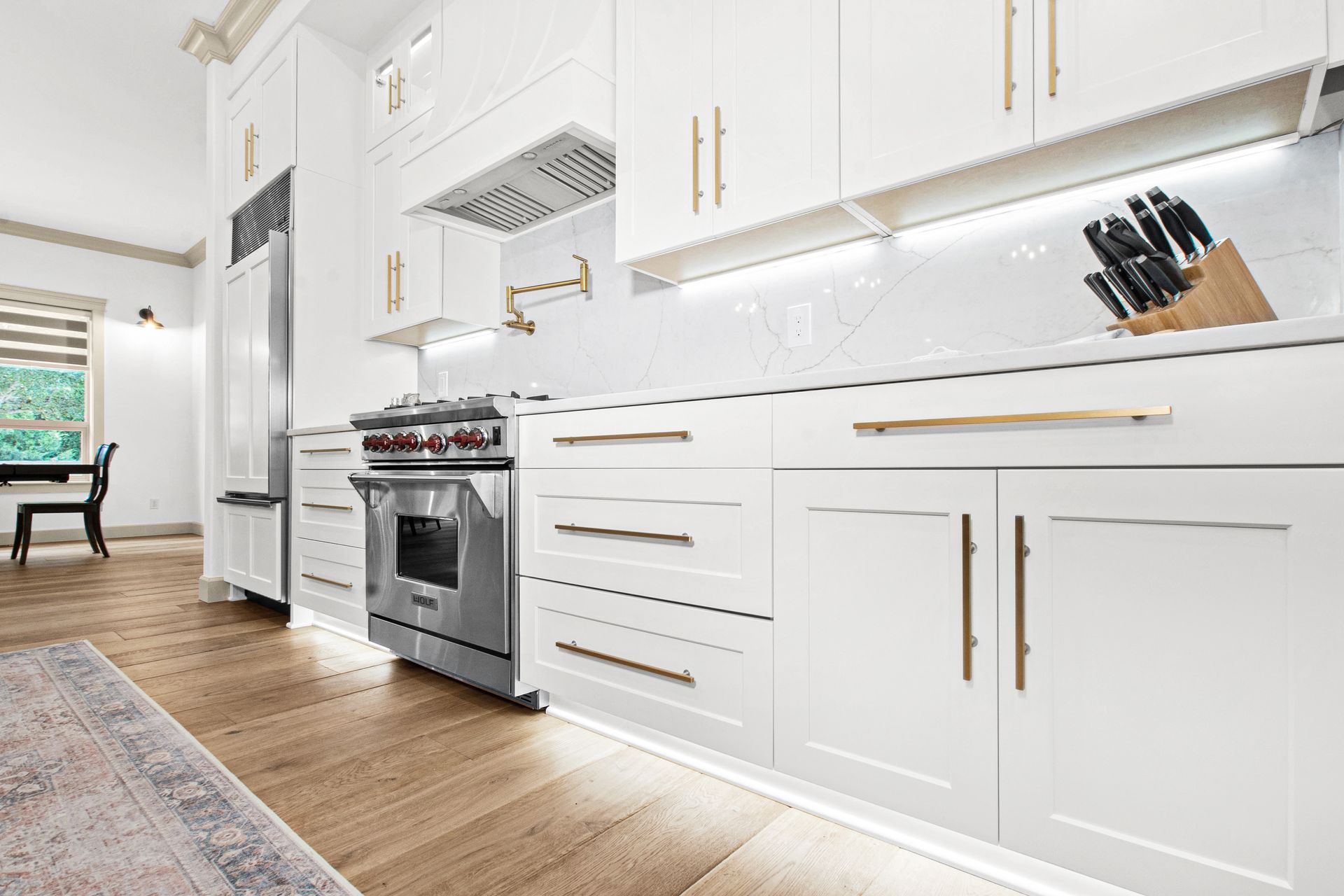 A kitchen with white cabinets and stainless steel appliances.