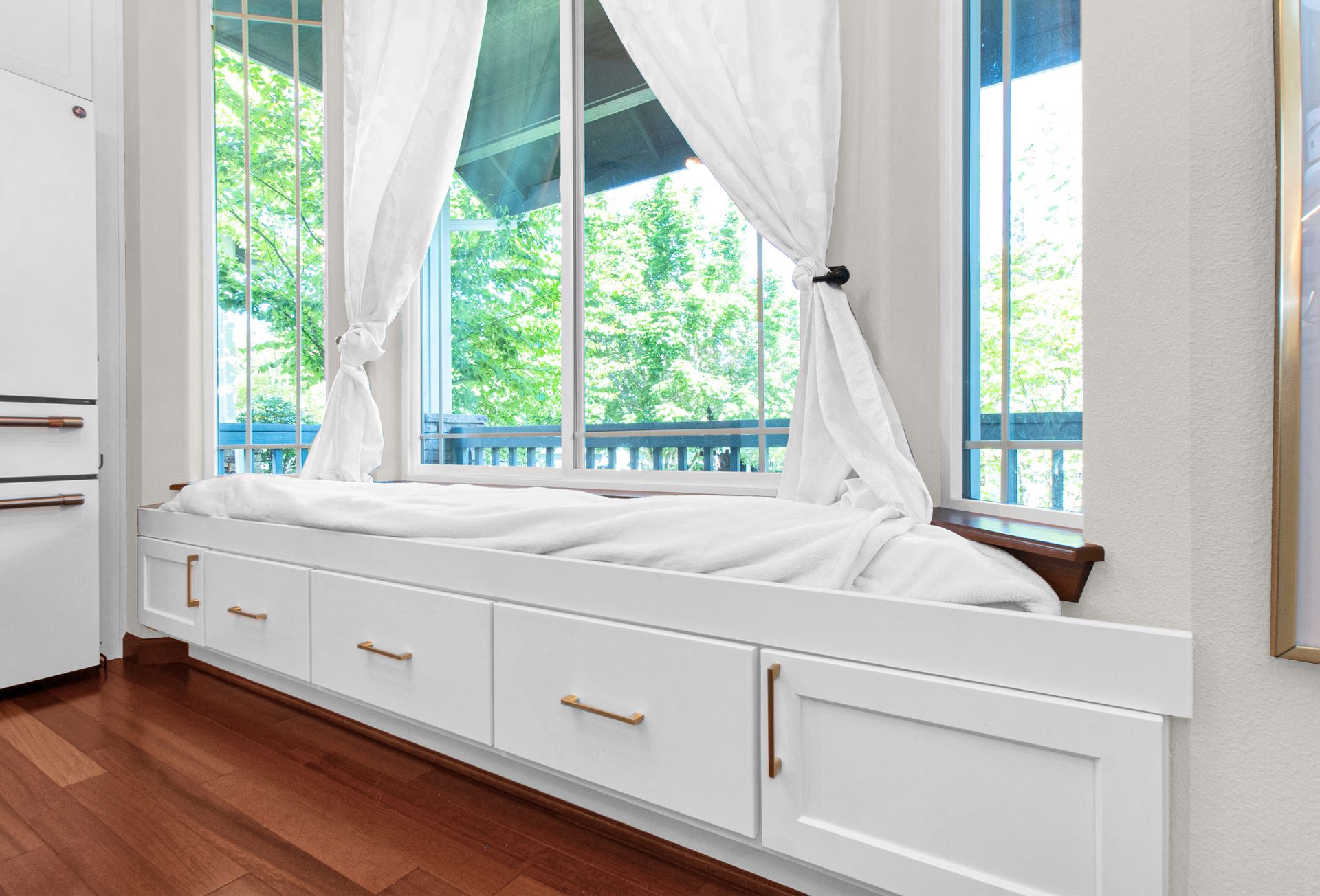 A window seat with drawers underneath it in a kitchen.