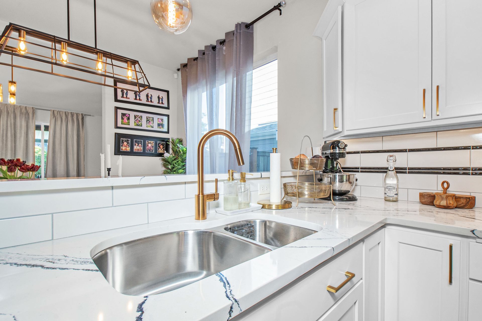 A kitchen with white cabinets and a stainless steel sink.