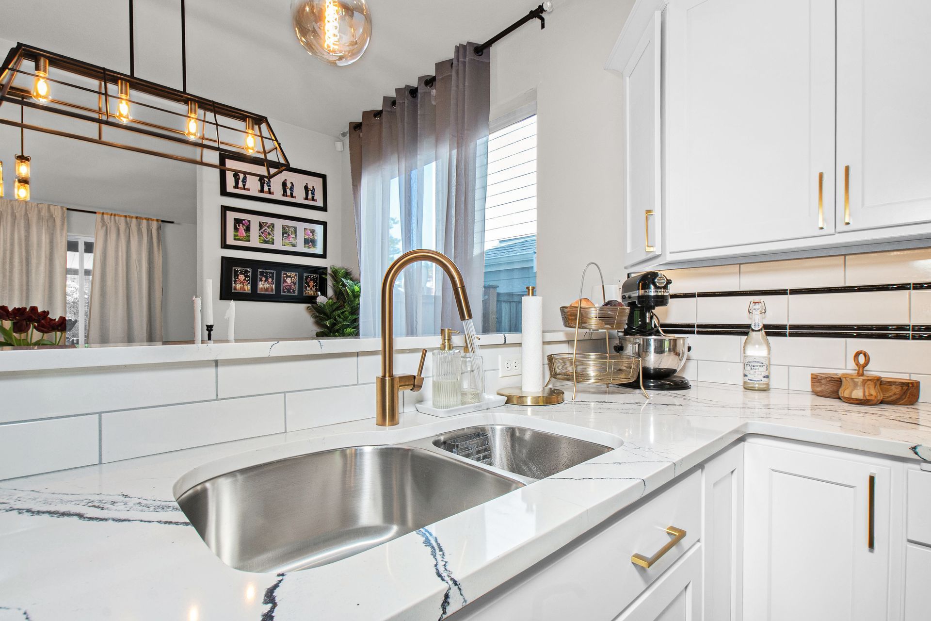 A kitchen with white cabinets and a stainless steel sink.