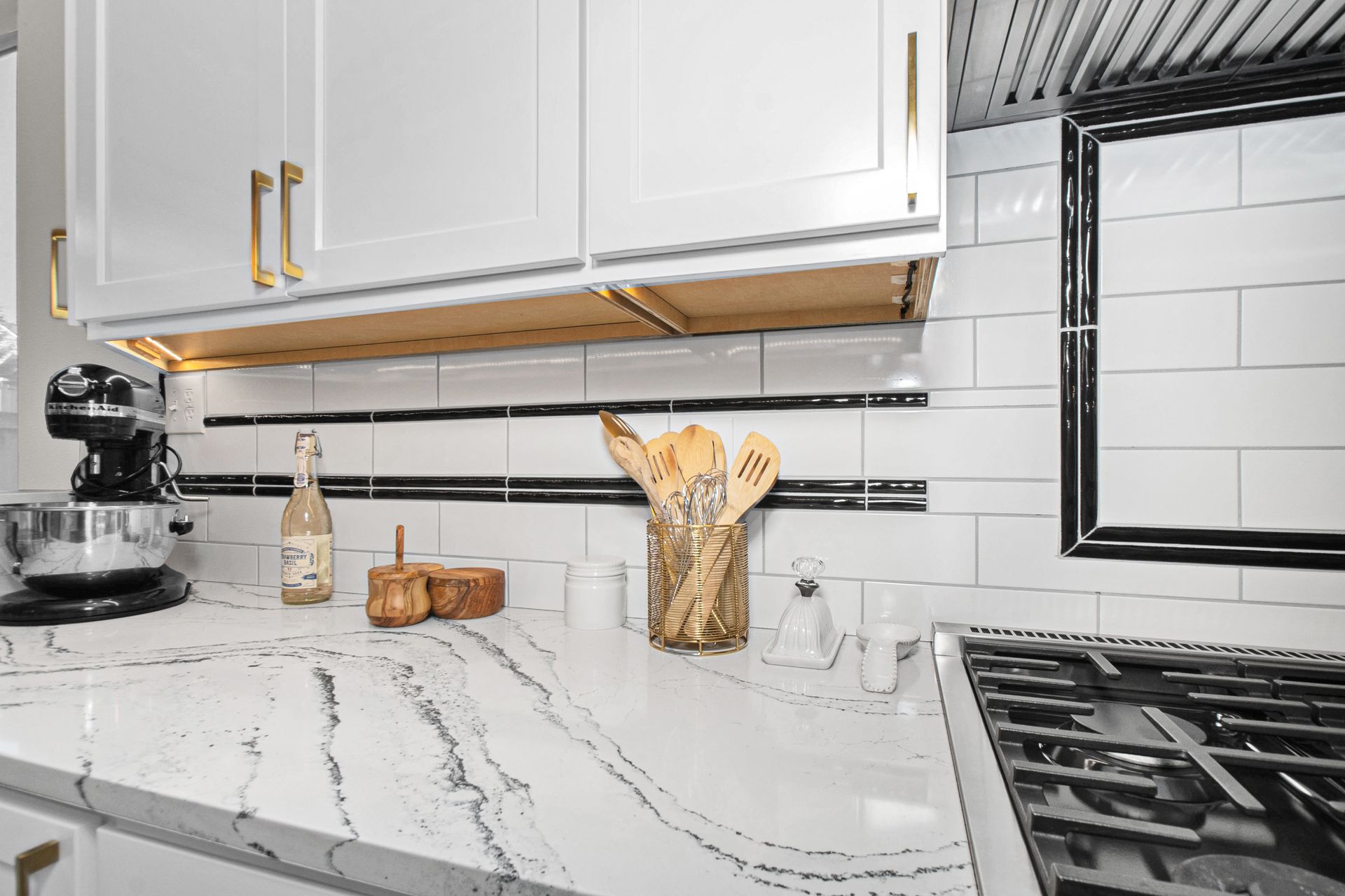 A kitchen with white cabinets and a stove top oven.