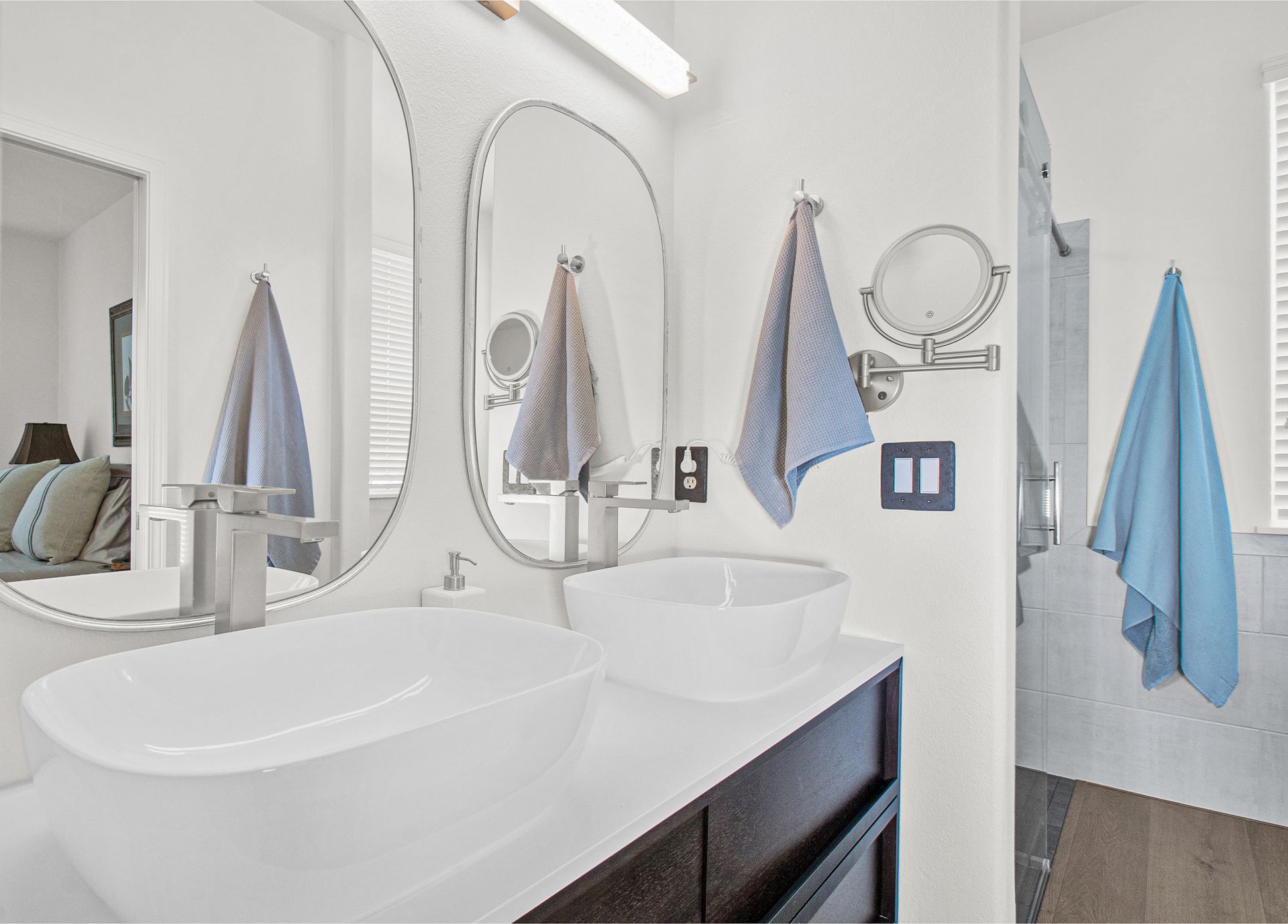 A bathroom with two sinks and a walk in shower.
