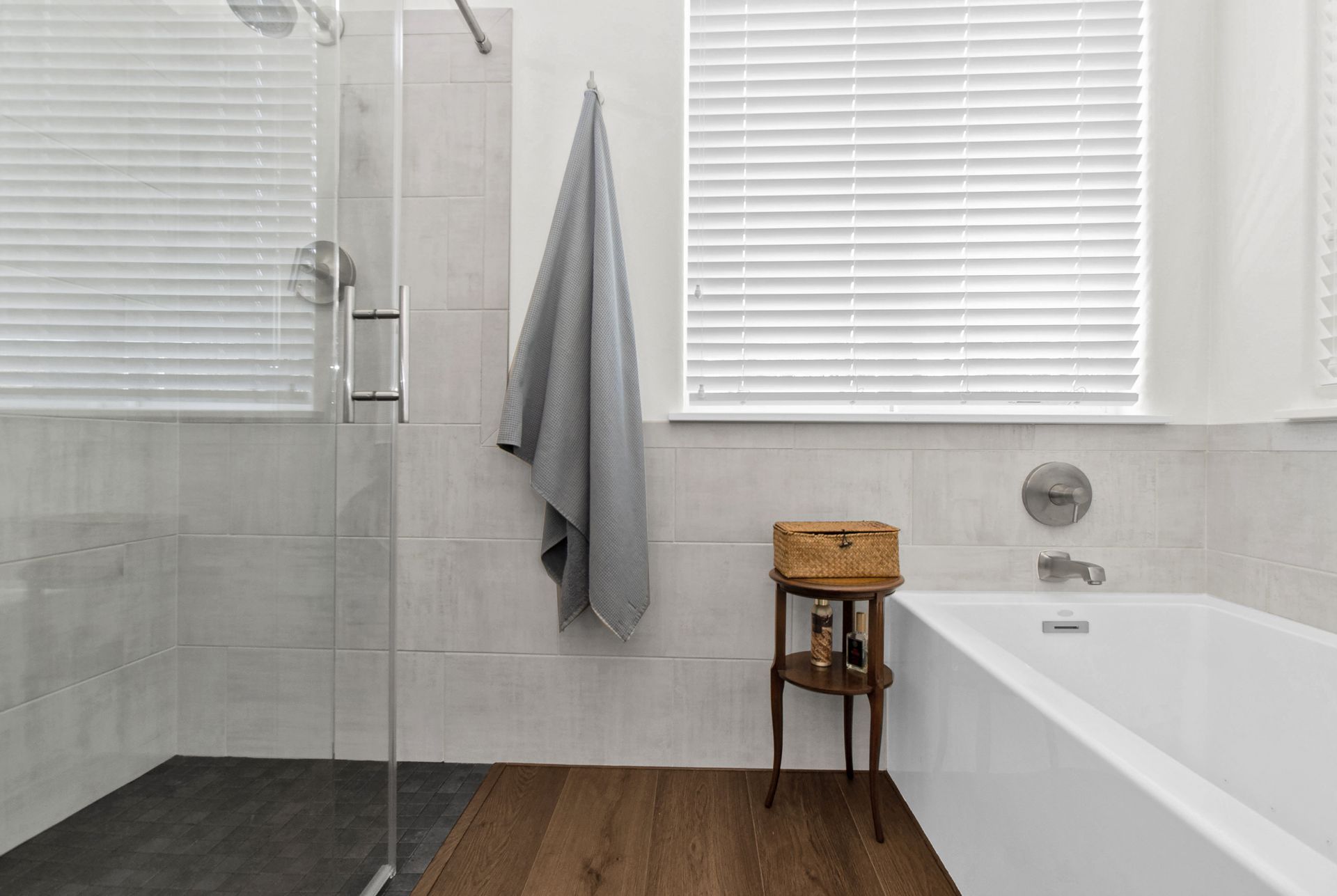 A bathroom with a bathtub , shower , and window.