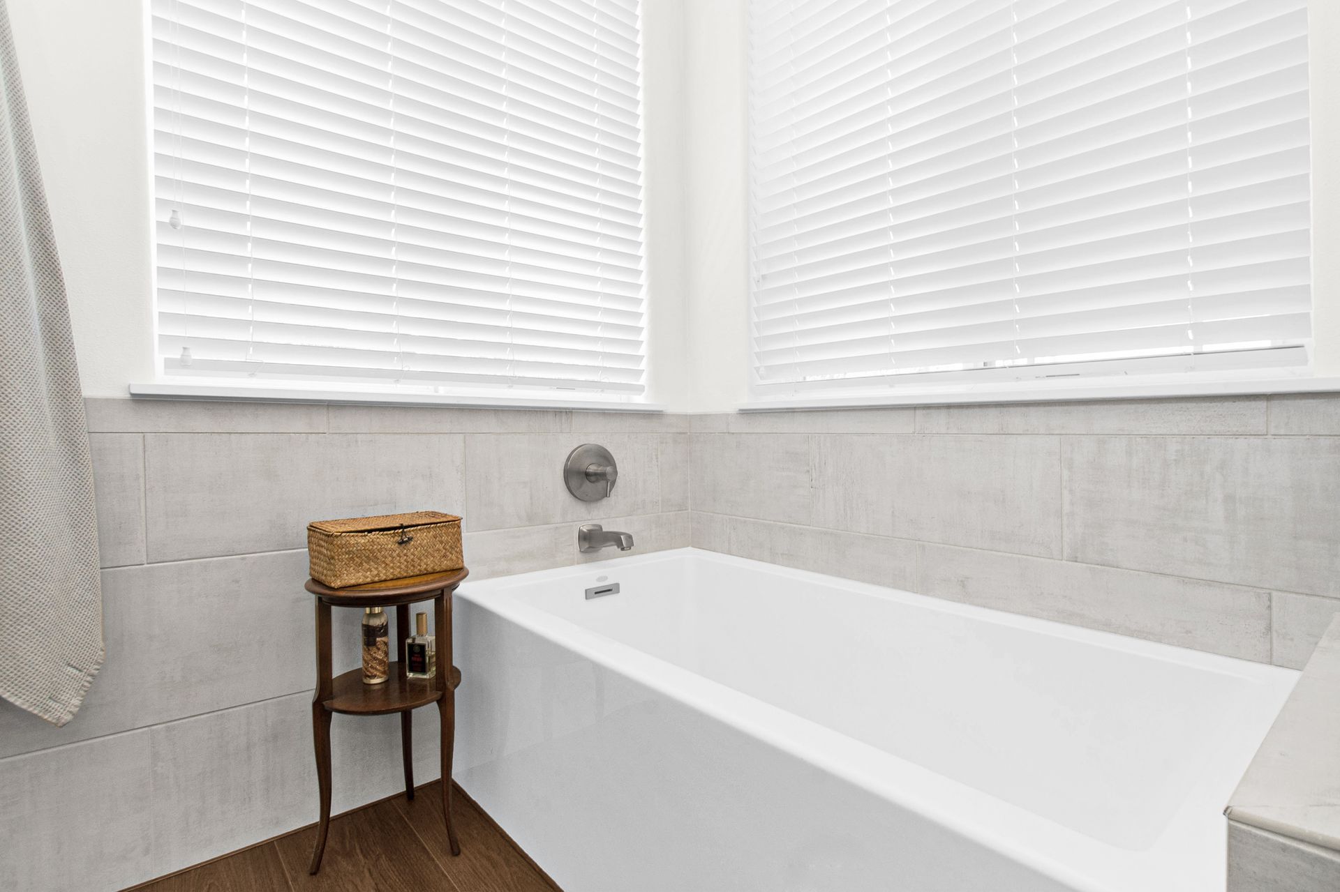 A bathroom with a bathtub and a window with blinds.