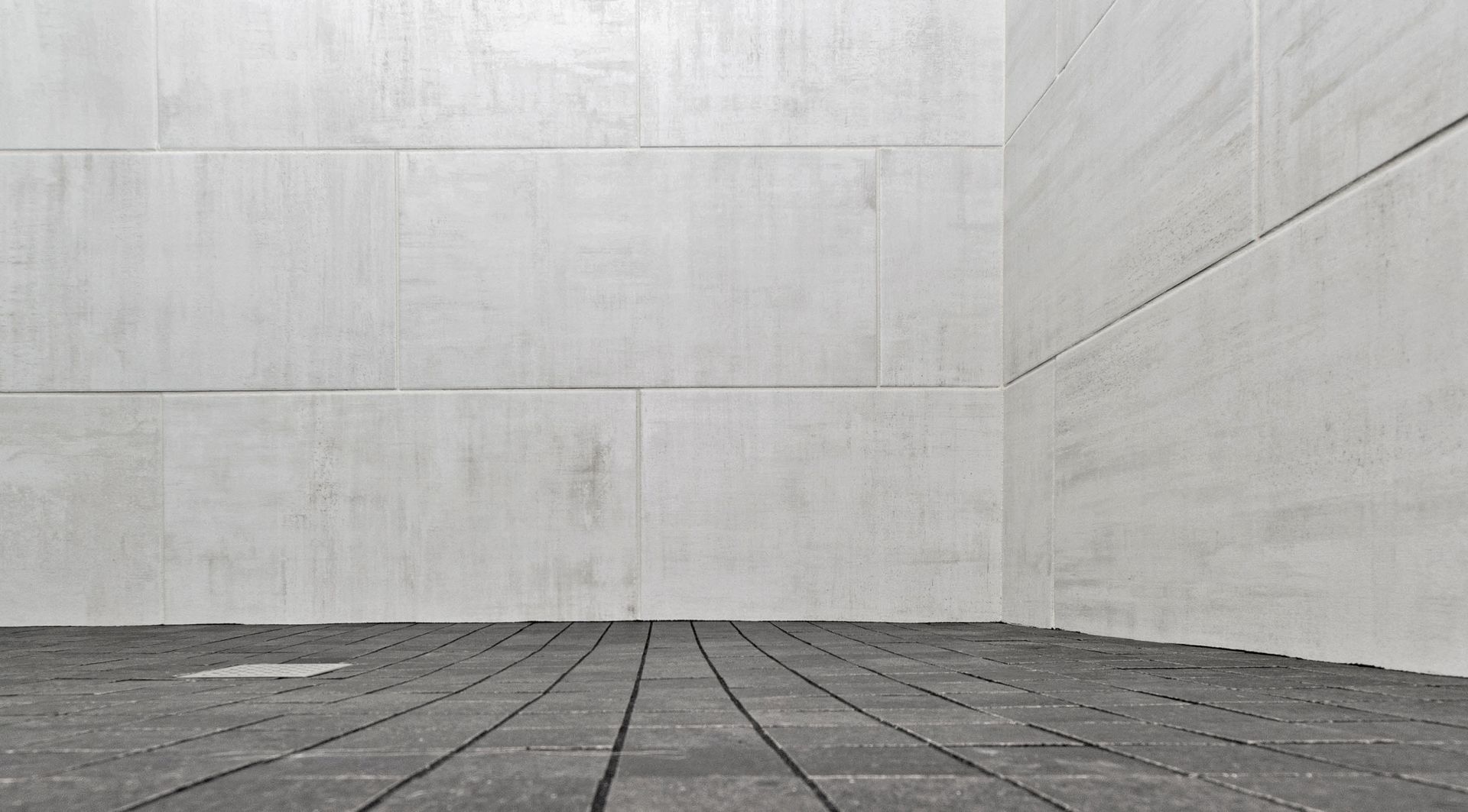 An empty room with a concrete wall and a concrete floor.