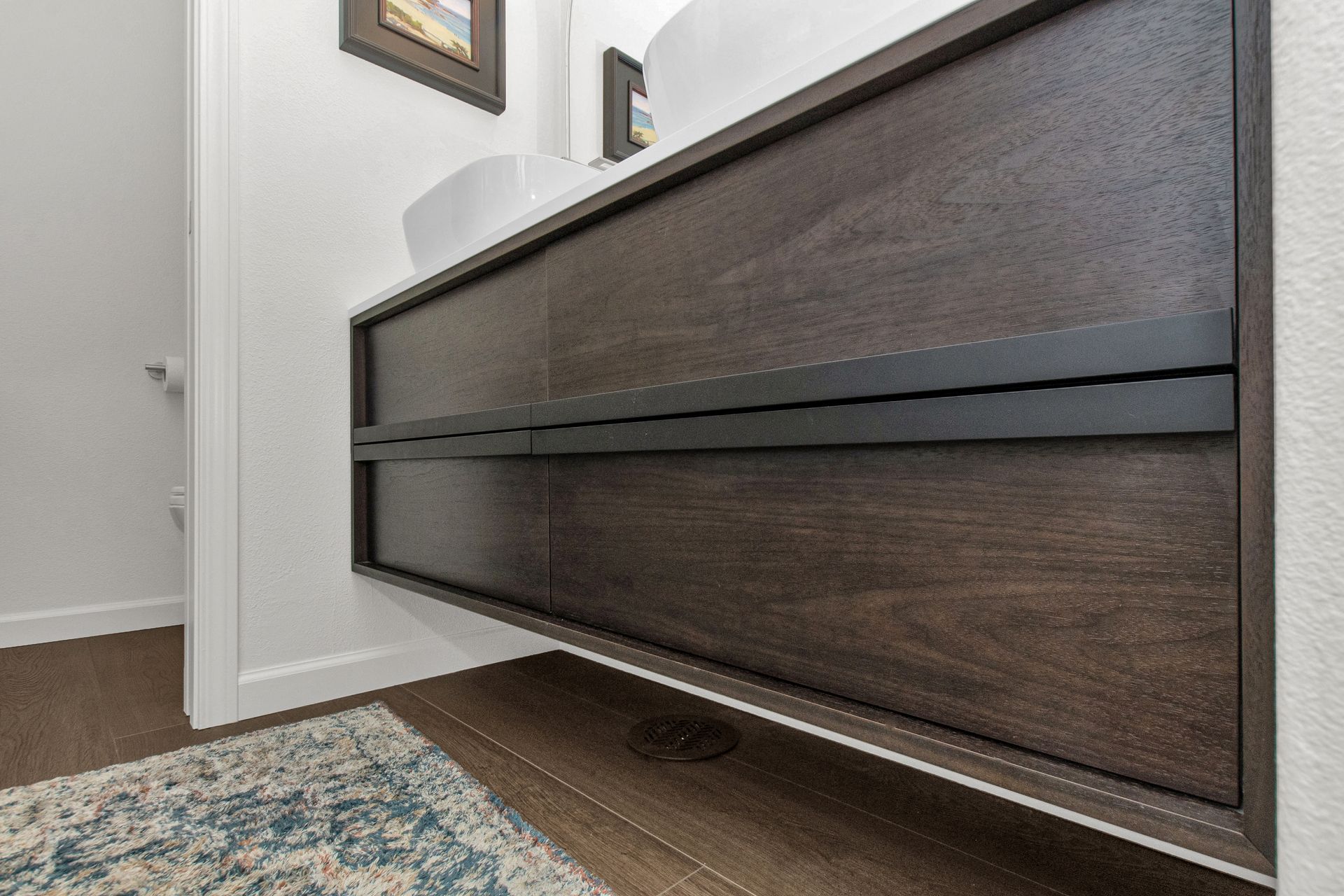 A bathroom with a wooden vanity and a sink.