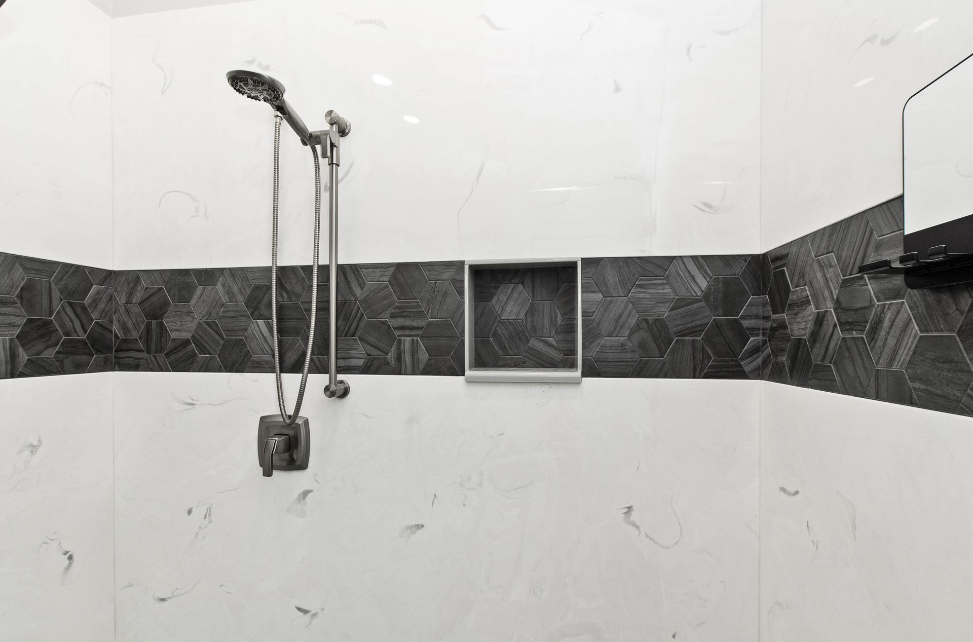 A black and white photo of a bathroom with a shower head.
