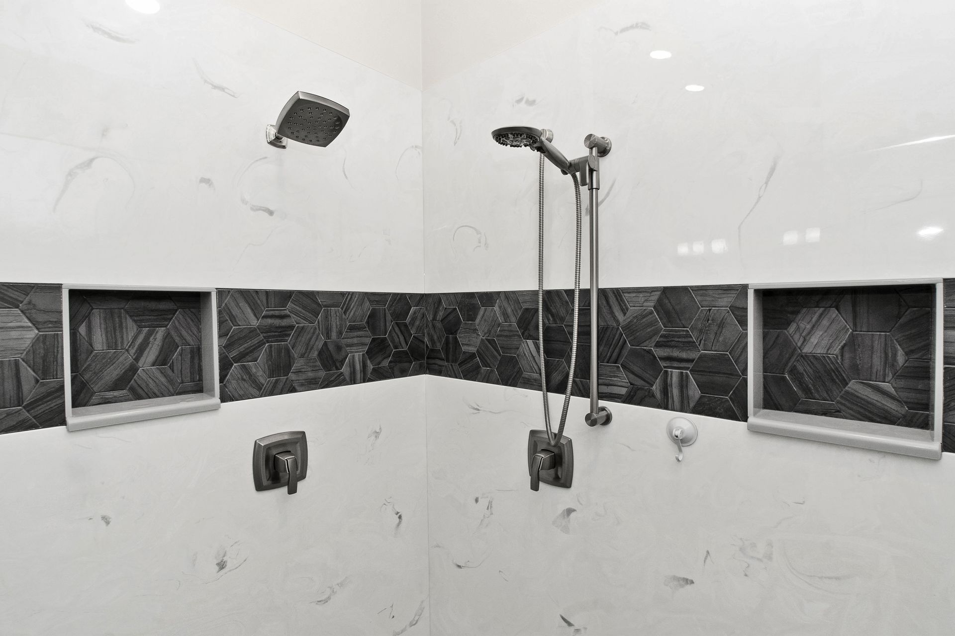 A black and white photo of a shower with a shower head.