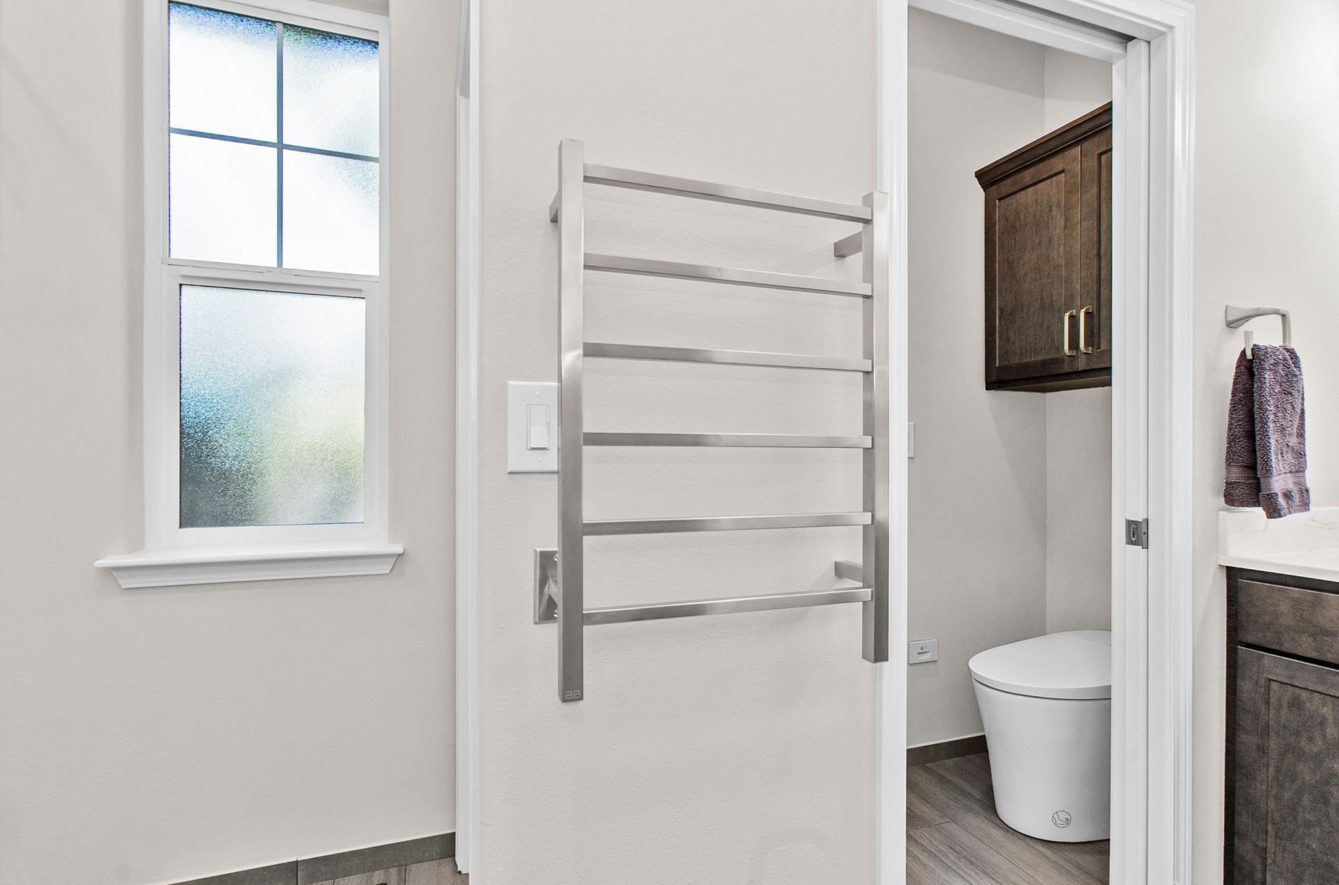 A bathroom with a towel rack and a toilet.
